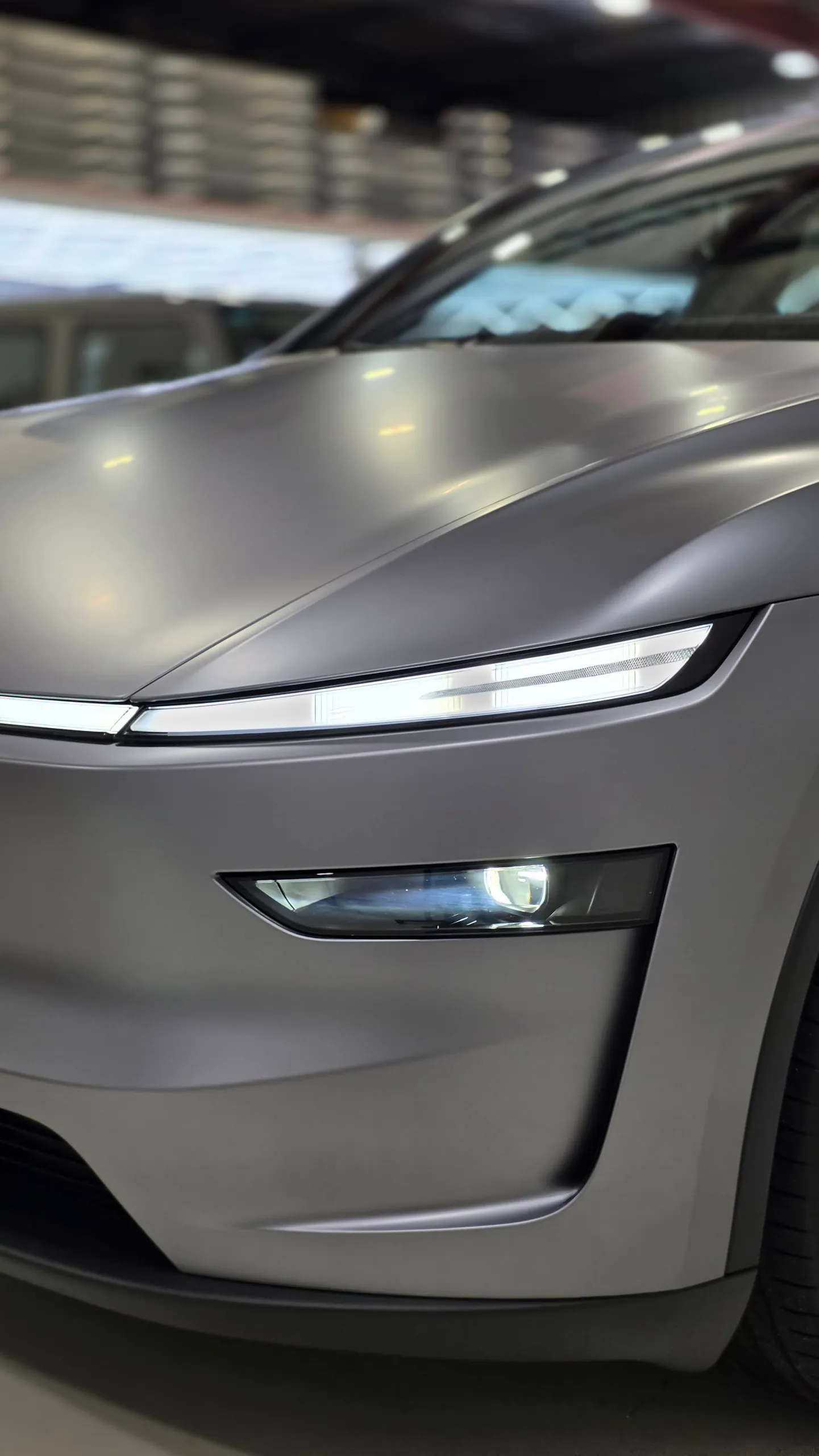 Satin grey Tesla Model Y front light bar and lower headlight in the workshop
