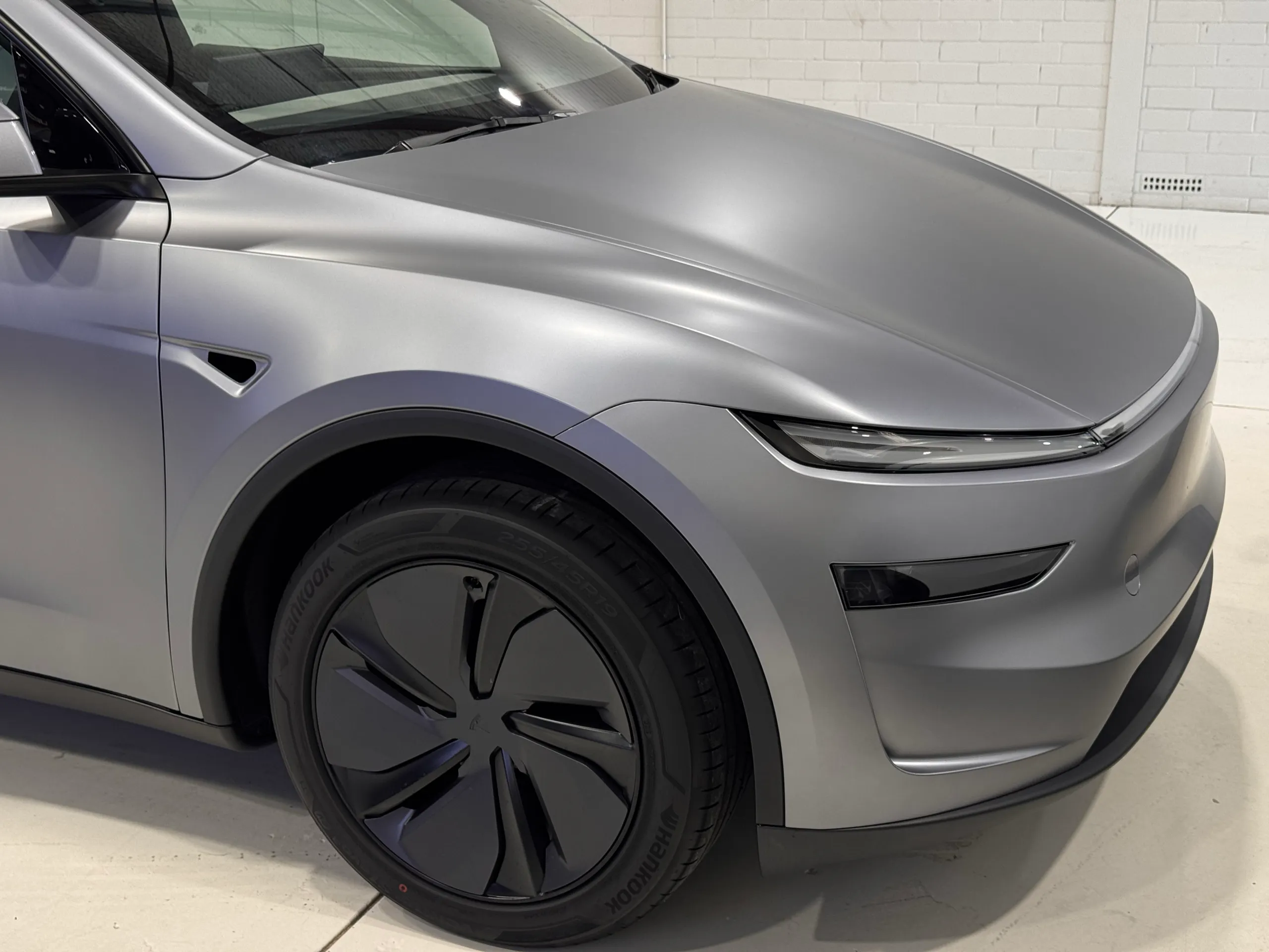 Satin grey Tesla Model Y front wheel, guard and bonnet in the workshop