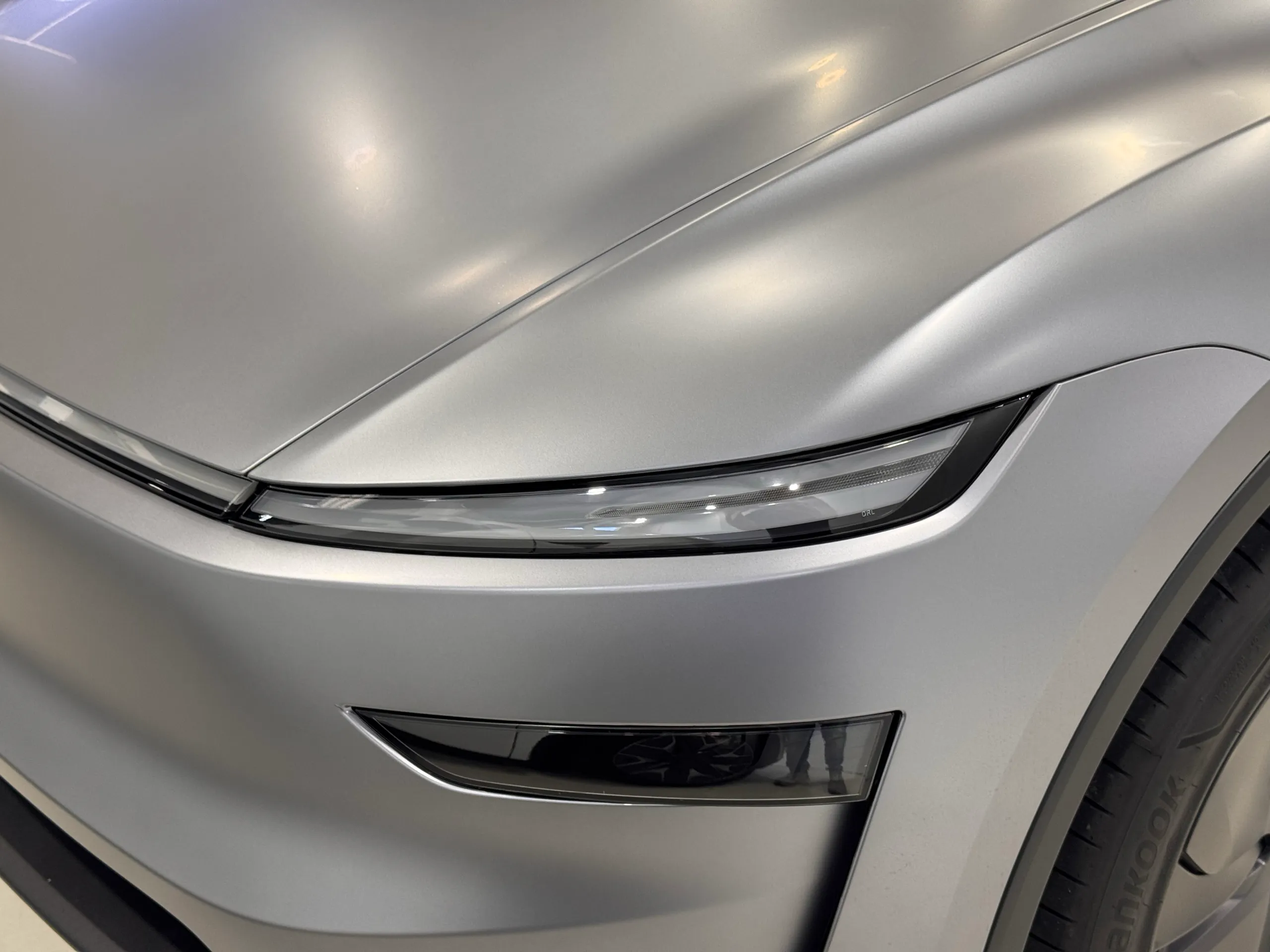 Satin grey panels above the Tesla Model Y front light bar and lower headlight
