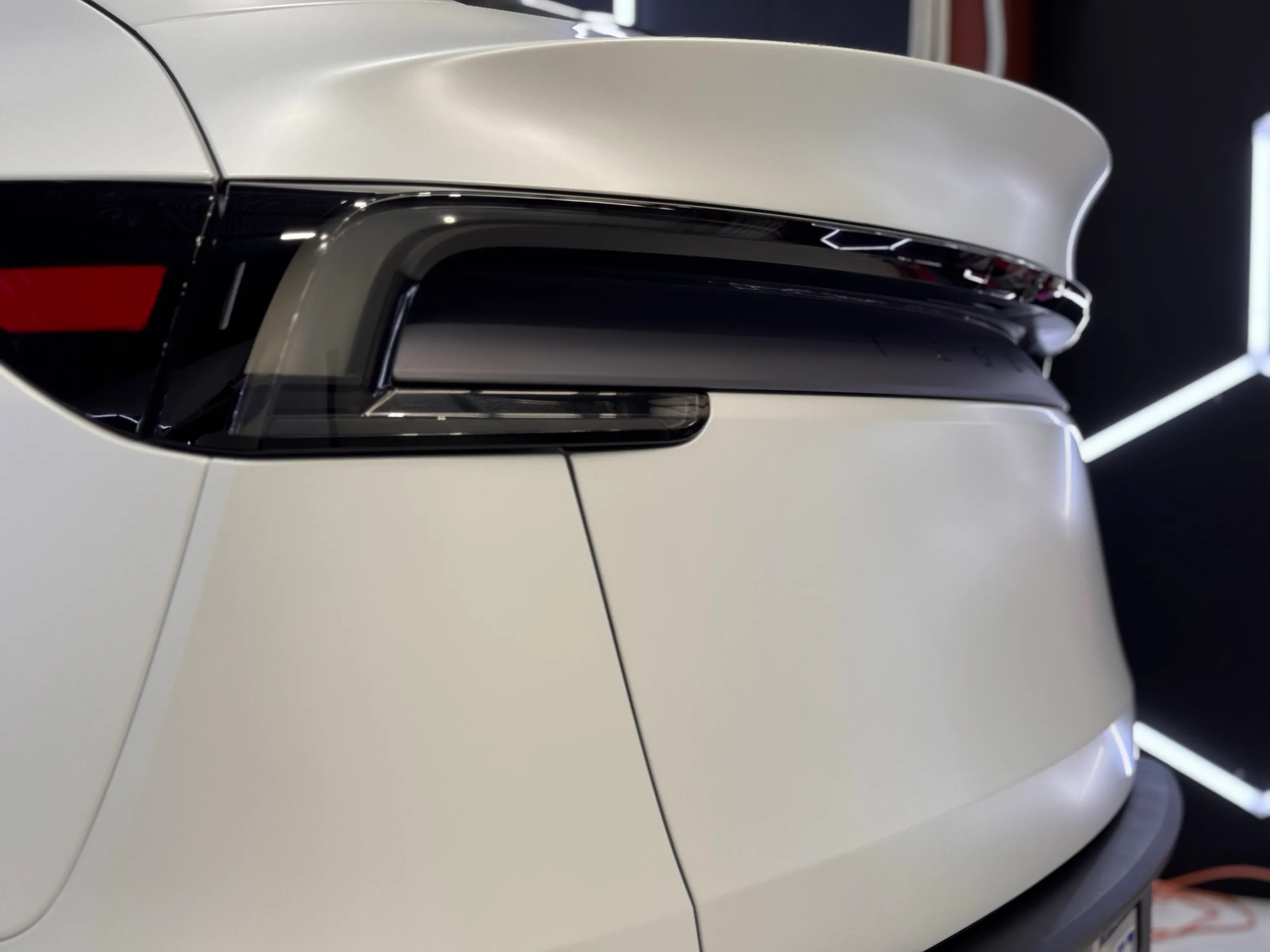 Close view of the Tesla Model Y rear light bar and white tailgate