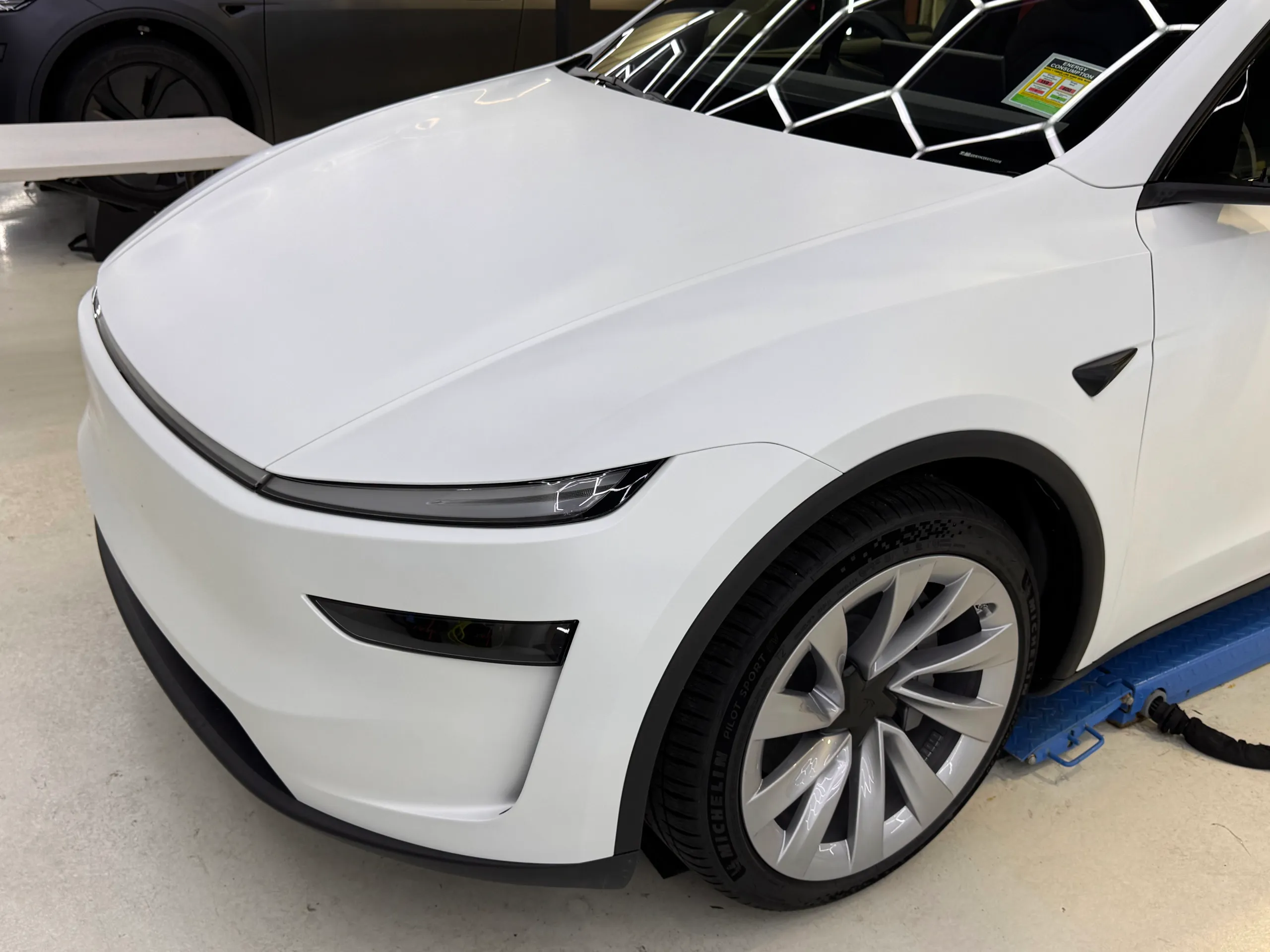 Satin white Tesla Model Y bonnet, front light bar and wheel viewed from above