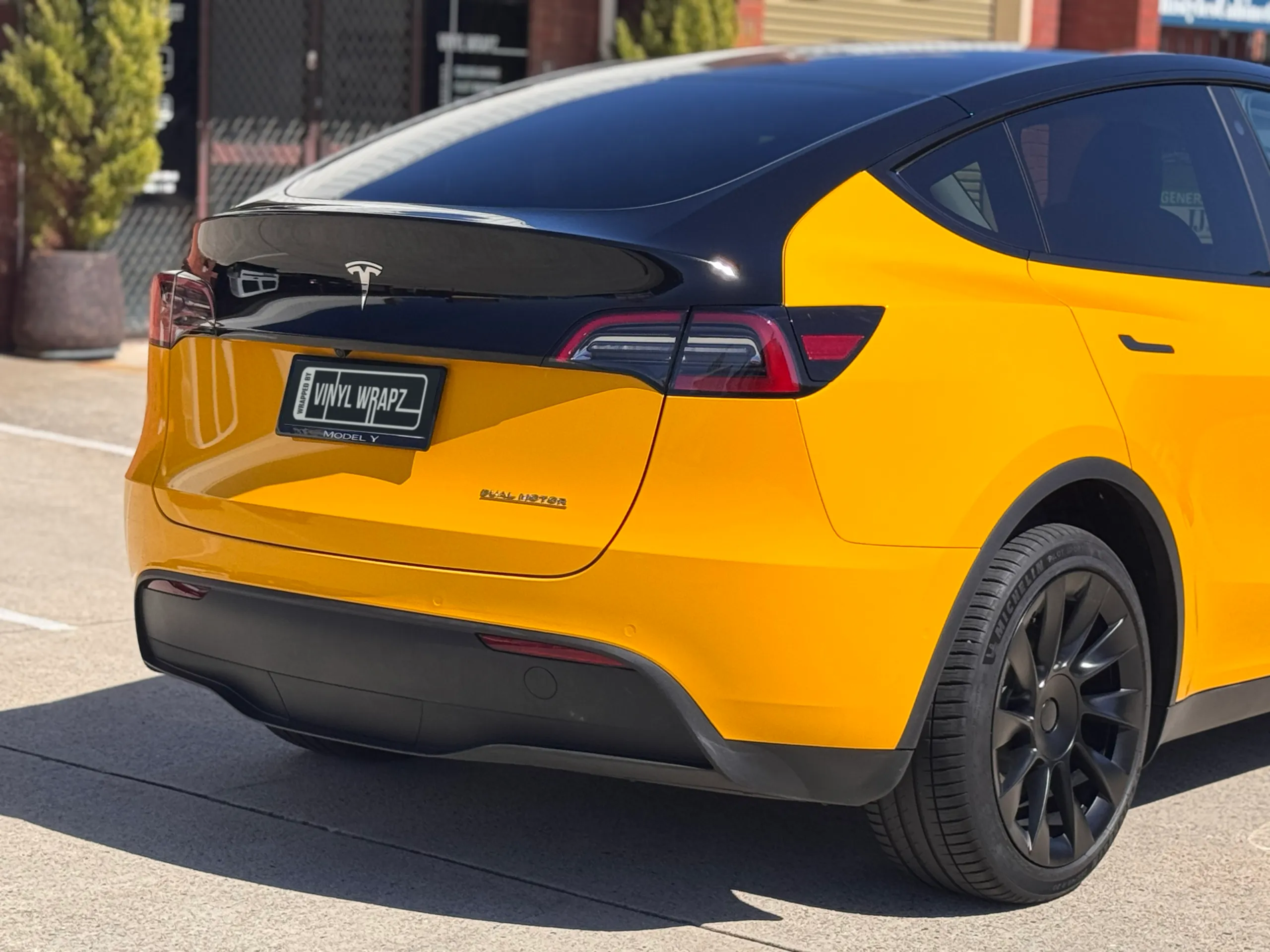 Yellow Tesla Model Y rear quarter with a contrasting gloss black upper tailgate