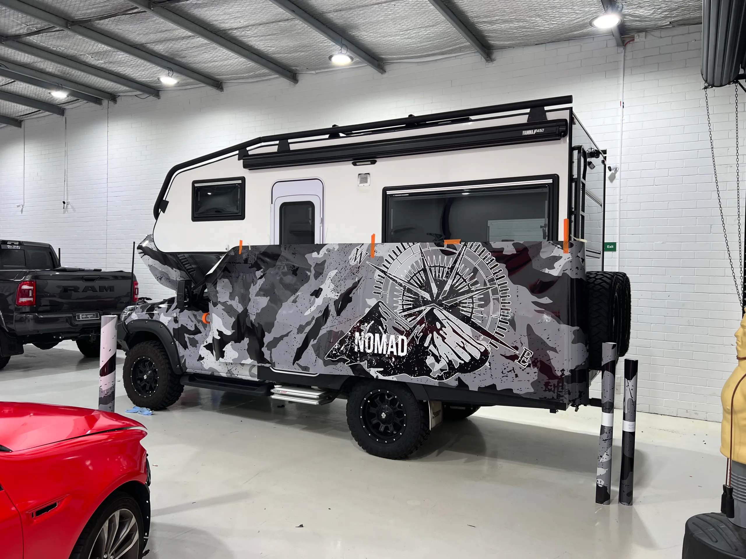 Camouflage film with a compass graphic positioned along the Suncamper side during wrapping