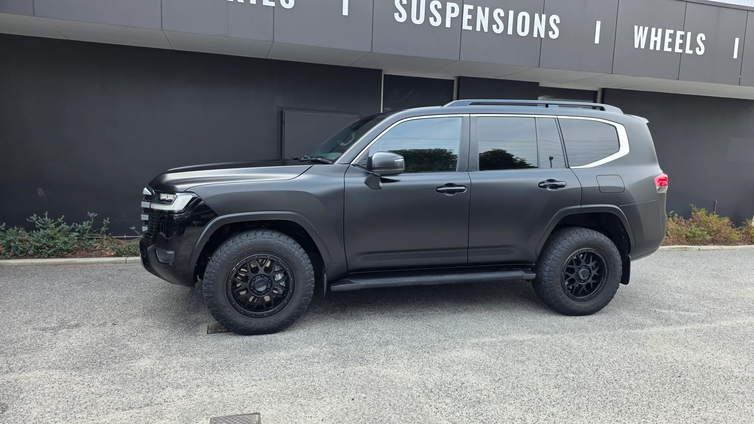 Side profile of the satin black Toyota LandCruiser 300 with black wheels