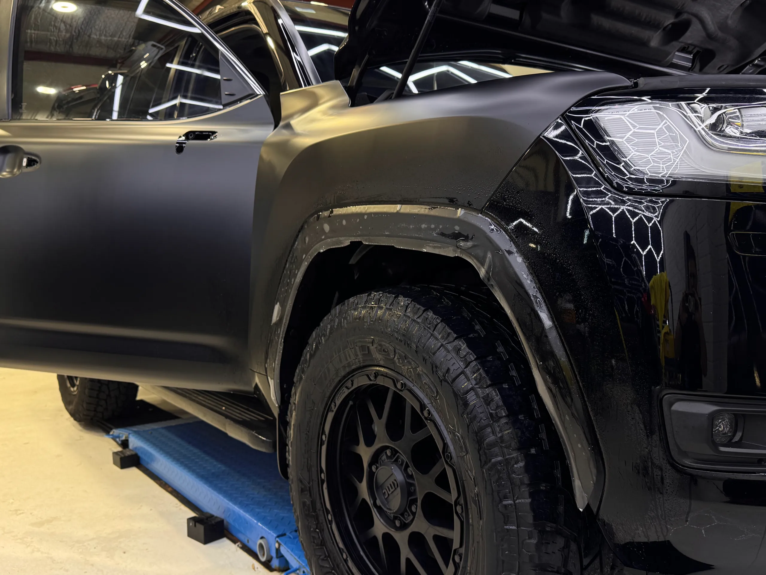 Satin LandCruiser front guard and door beside remaining gloss bodywork during installation
