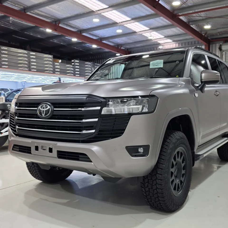Satin bronze-grey Toyota LandCruiser 300 in the workshop with black off-road wheels