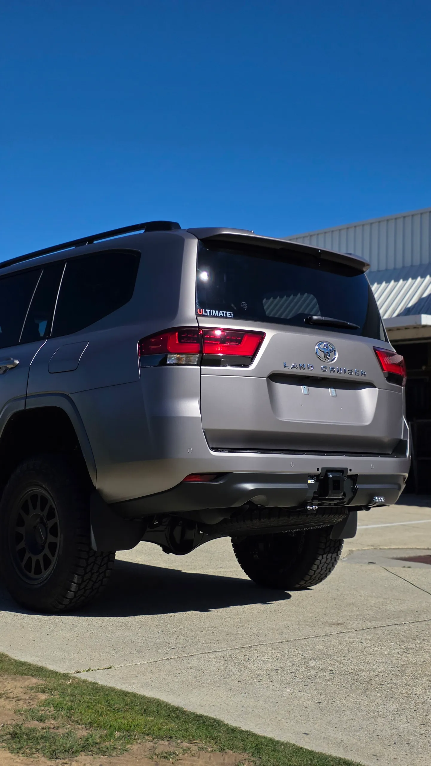 Satin bronze-grey LandCruiser 300 tailgate and rear bumper in sunlight