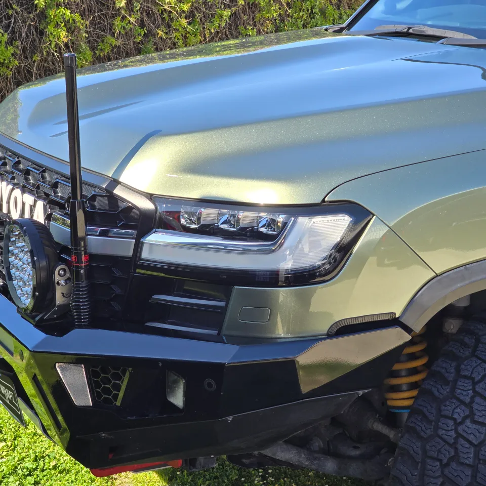 Metallic green LandCruiser bonnet, headlight and front bar in sunlight