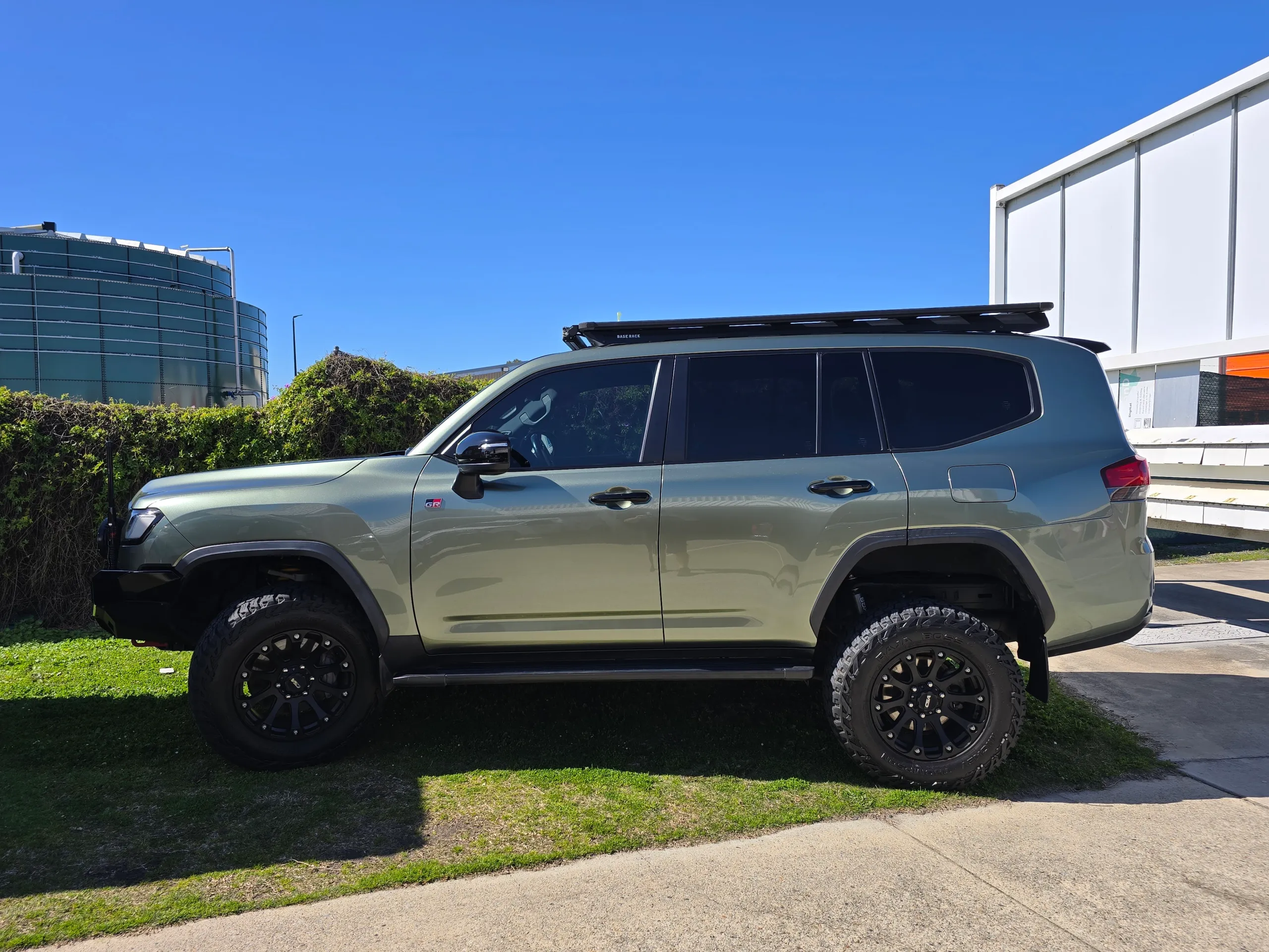 Gloss green LandCruiser 300 GR Sport in side profile outside the workshop