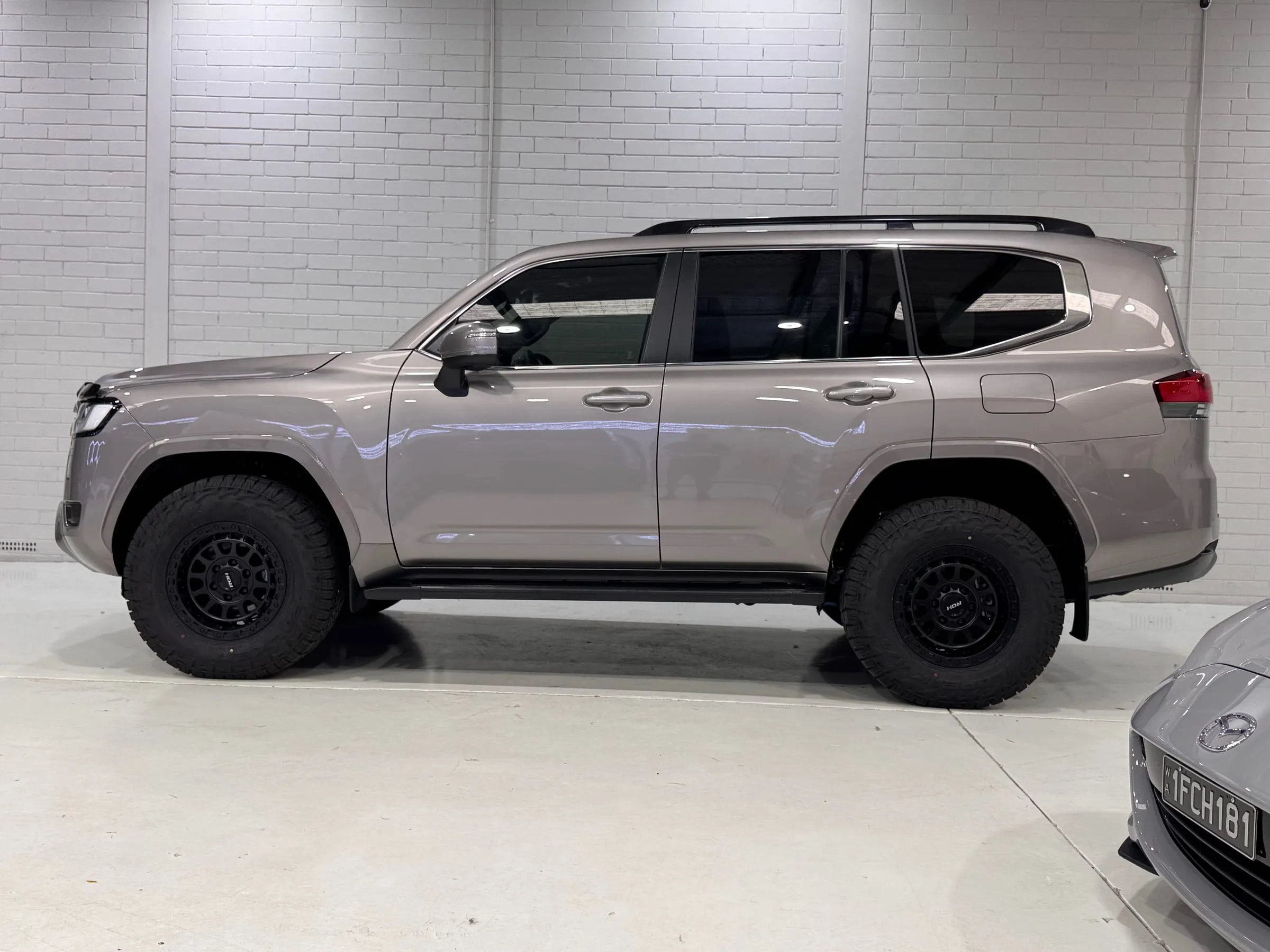 Grey Toyota LandCruiser 300 Series with clear paint protection film, side profile in the Vinyl Wrapz workshop, Osborne Park