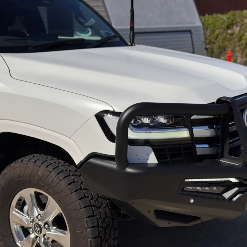 Matte white LandCruiser 300 front guard and black bull bar outdoors