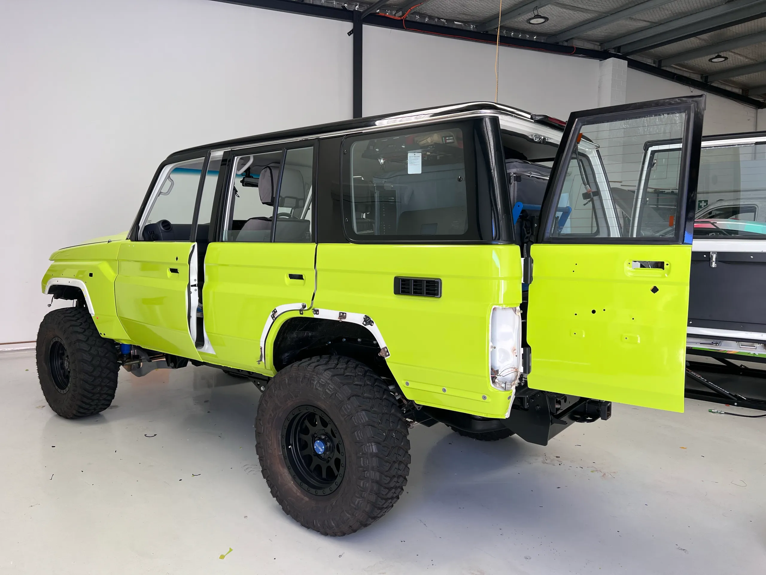 Lime green and black Toyota LandCruiser 76 Series, rear quarter