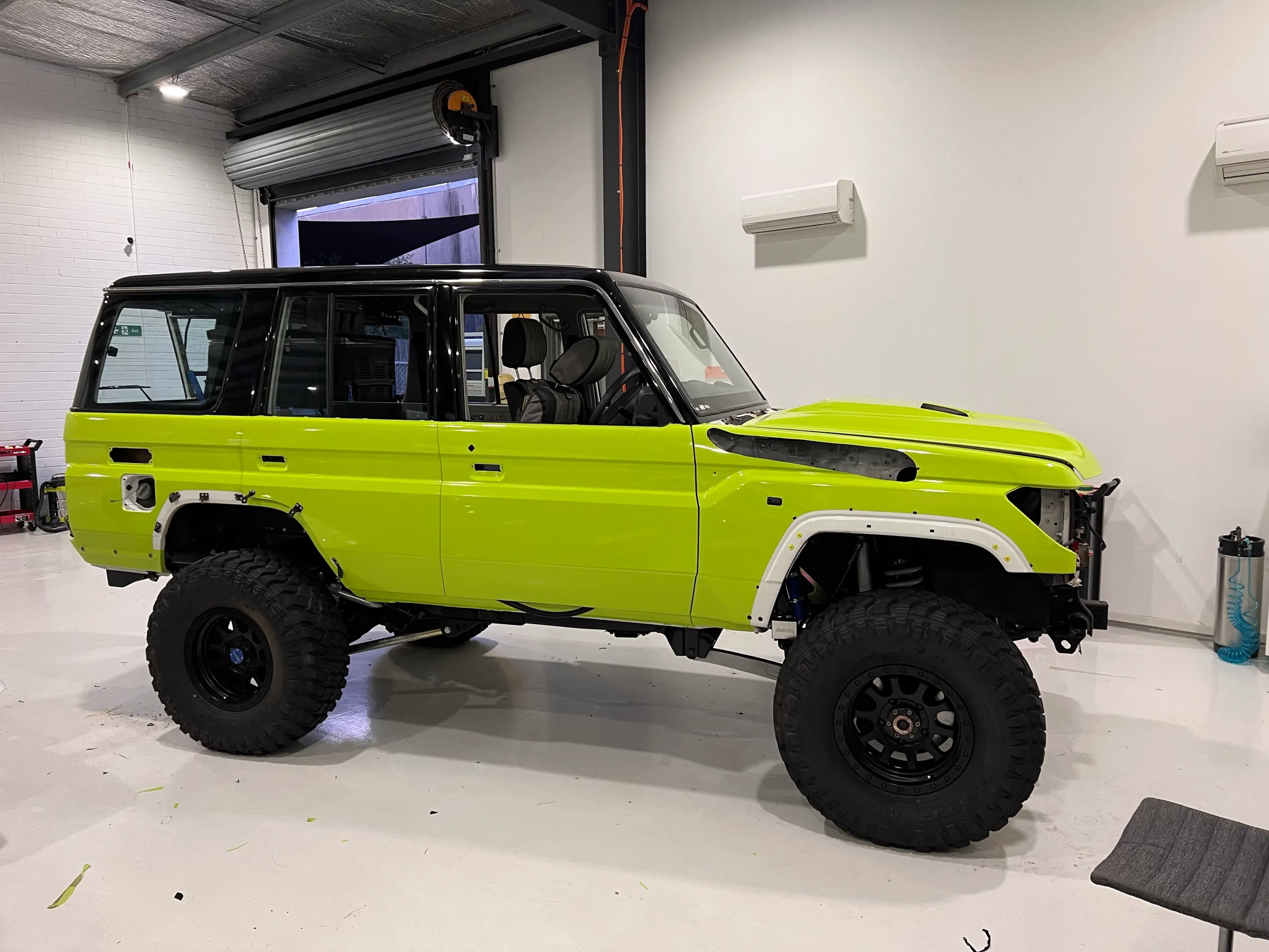 Lime green and black Toyota LandCruiser 76 Series, side