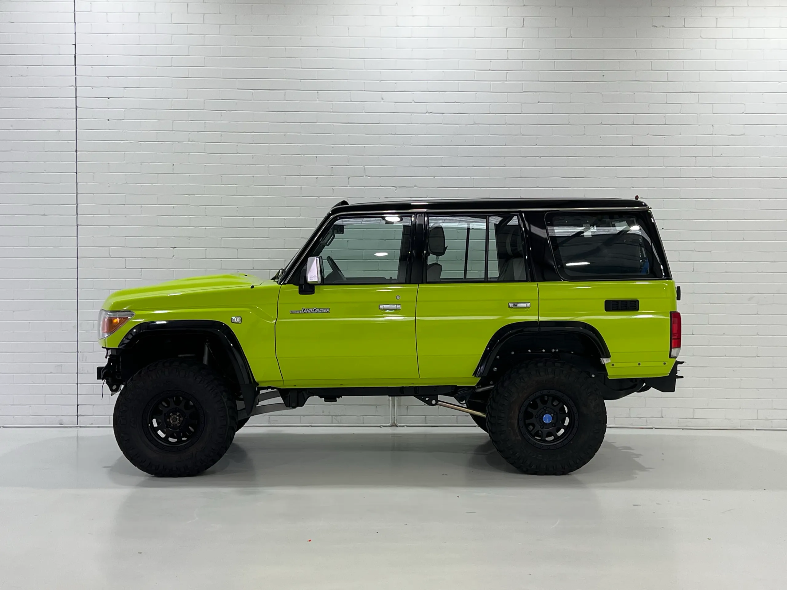 Lime green and black Toyota LandCruiser 76 Series, side