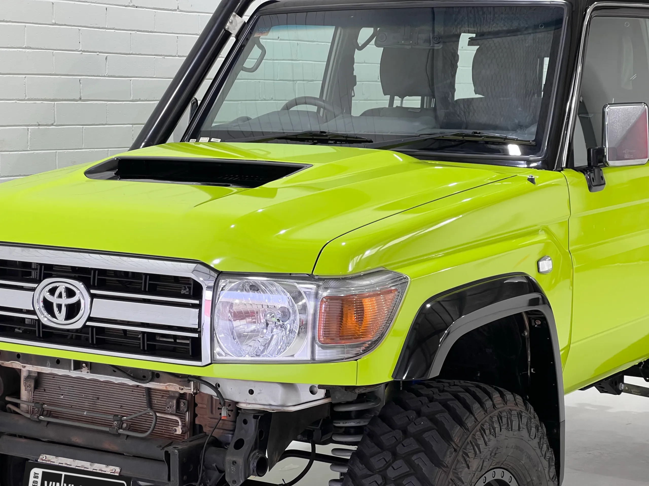 Lime green and black Toyota LandCruiser 76 Series, front detail