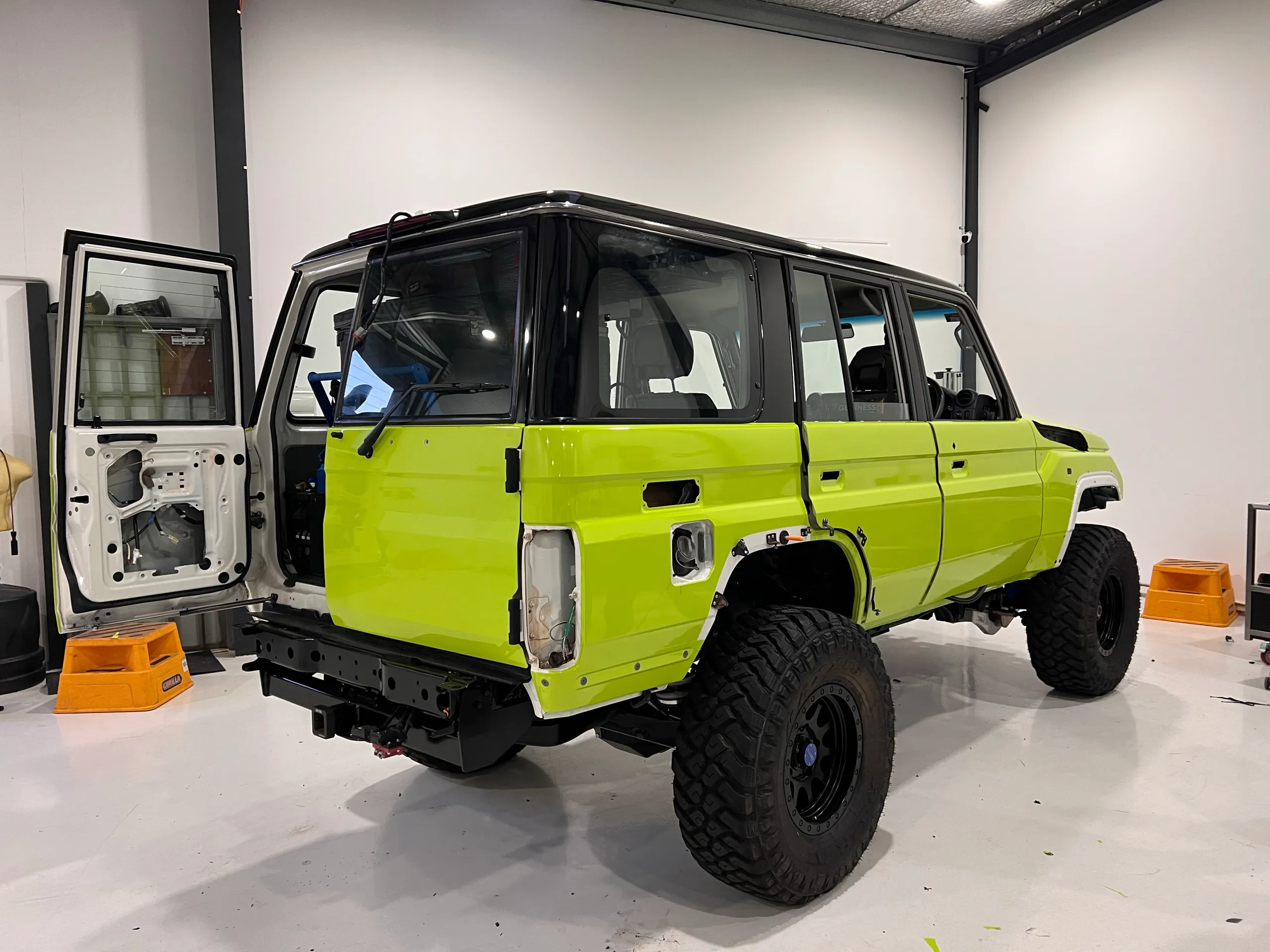 Lime green and black Toyota LandCruiser 76 Series, rear quarter
