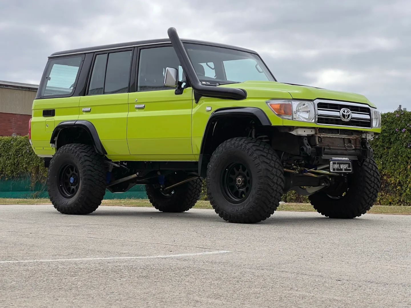 Lime green and black Toyota LandCruiser 76 Series, front quarter
