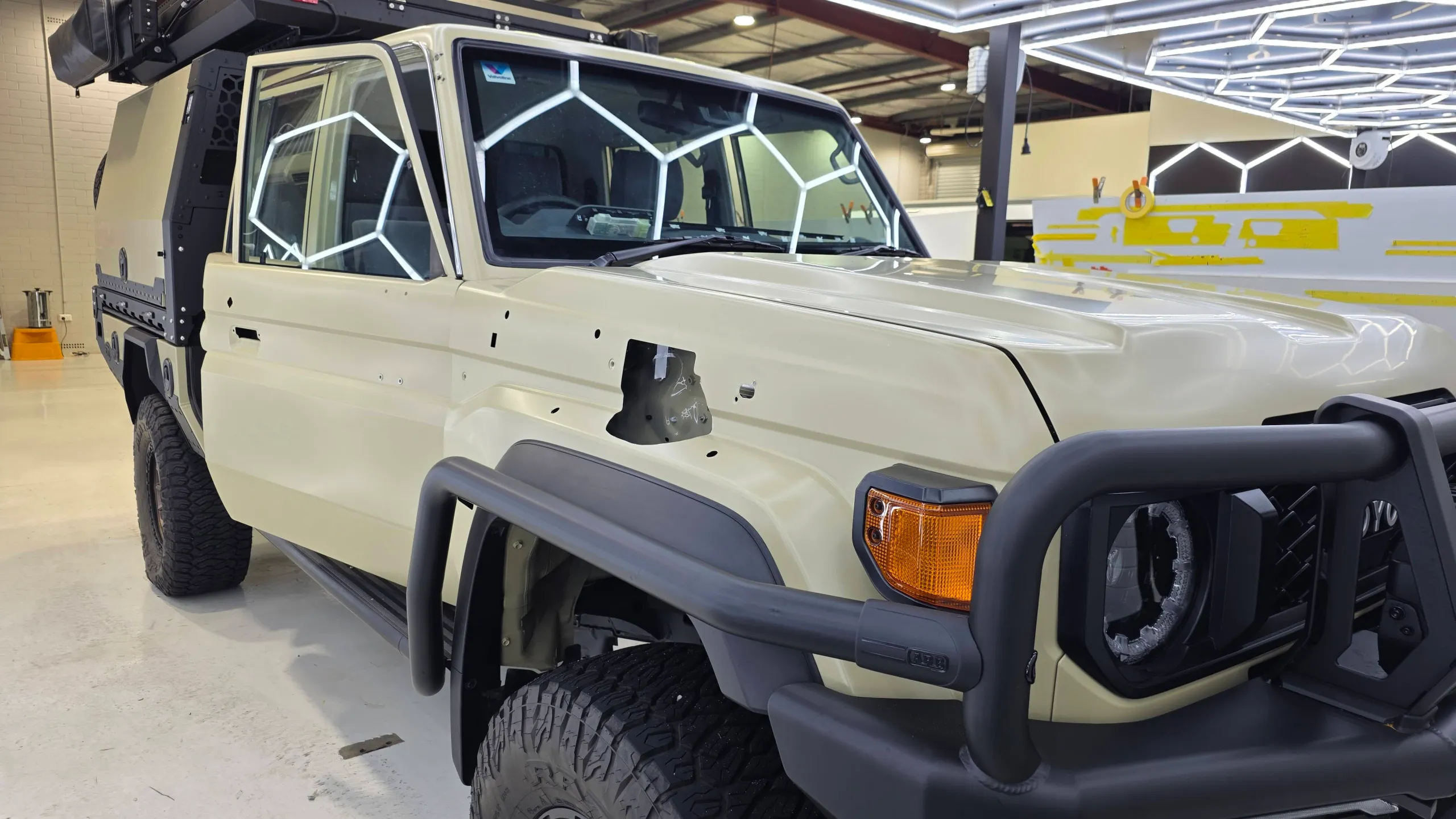 Cream LandCruiser 79 with its snorkel and door handles removed during preparation