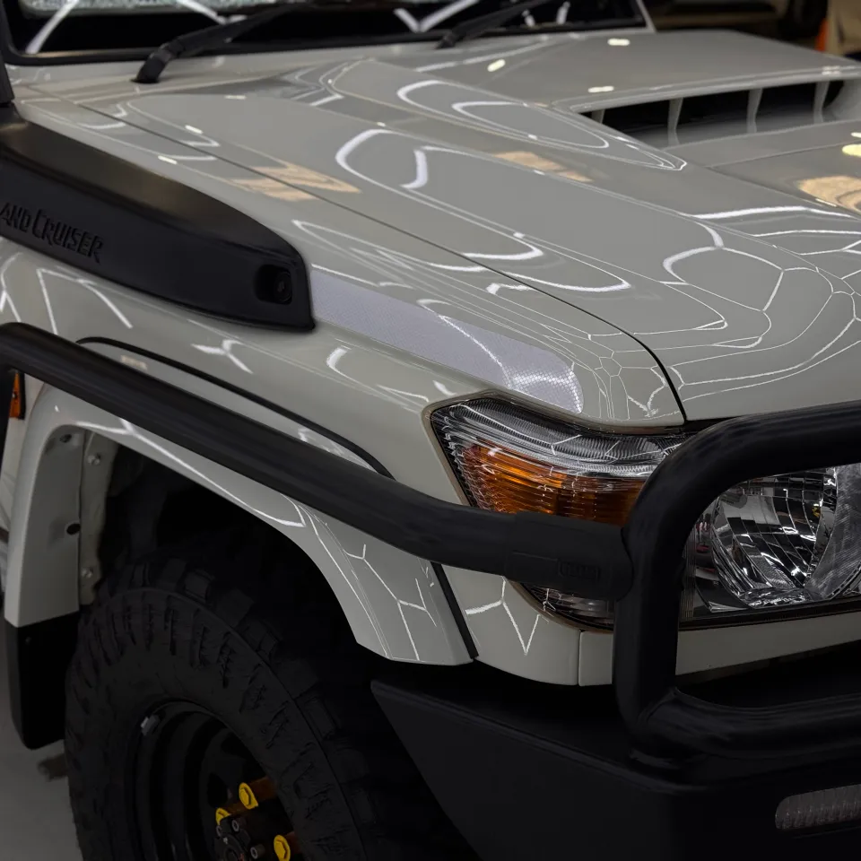 White LandCruiser front corner showing its snorkel, bonnet scoop and bullbar
