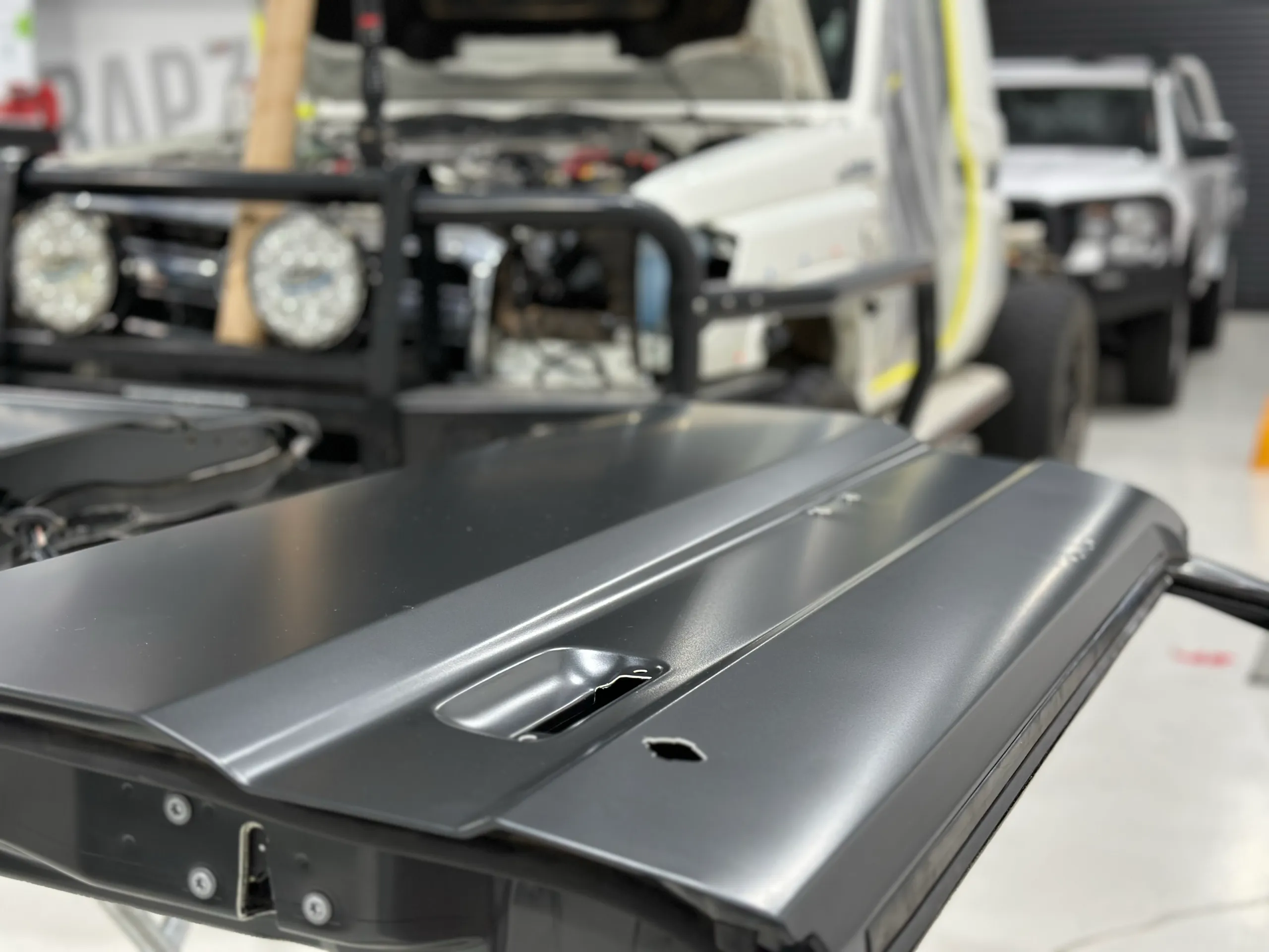 Detached LandCruiser door with dark grey film on its outer panel