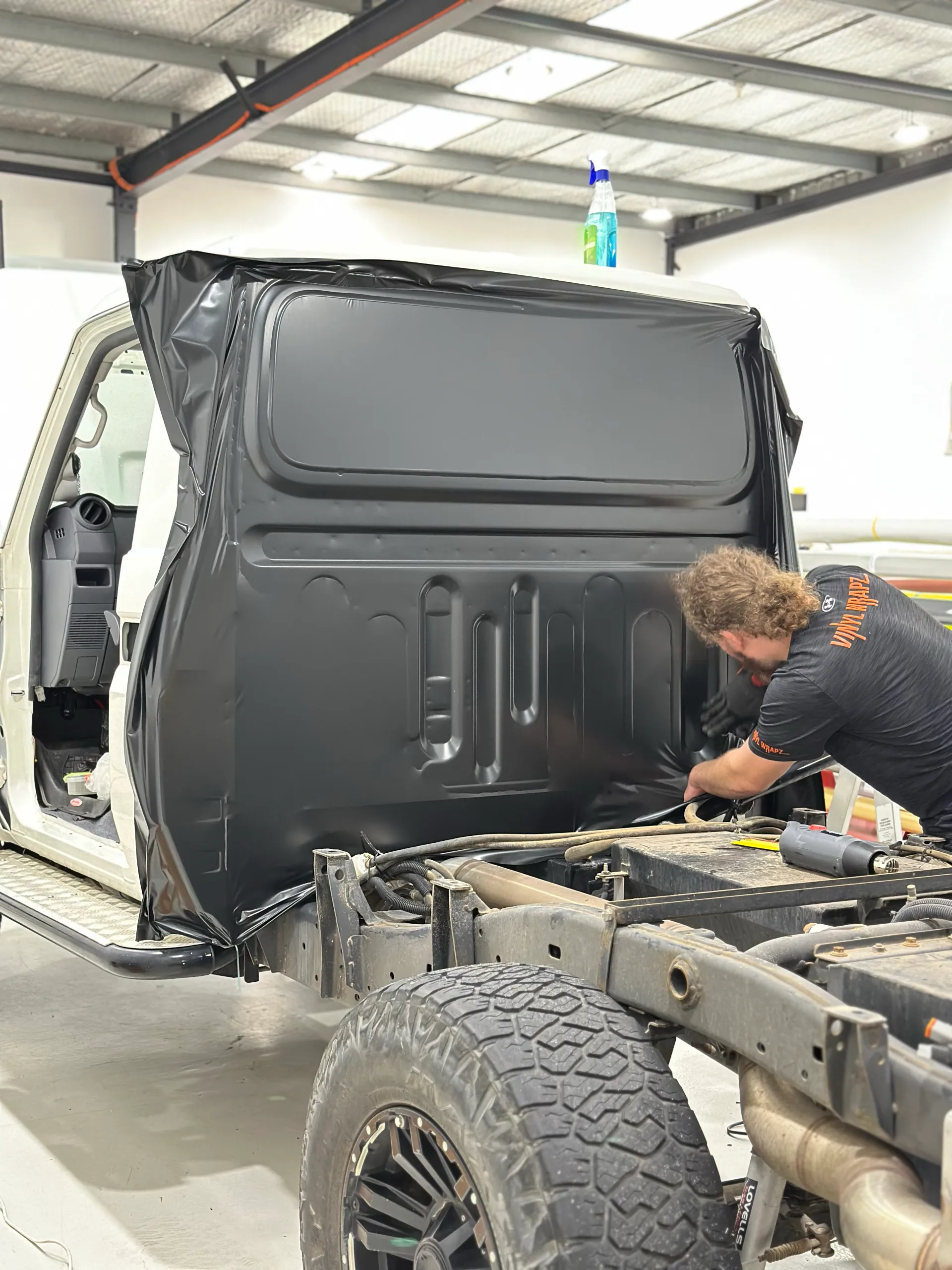 Installer working on dark film across the rear of the LandCruiser cab