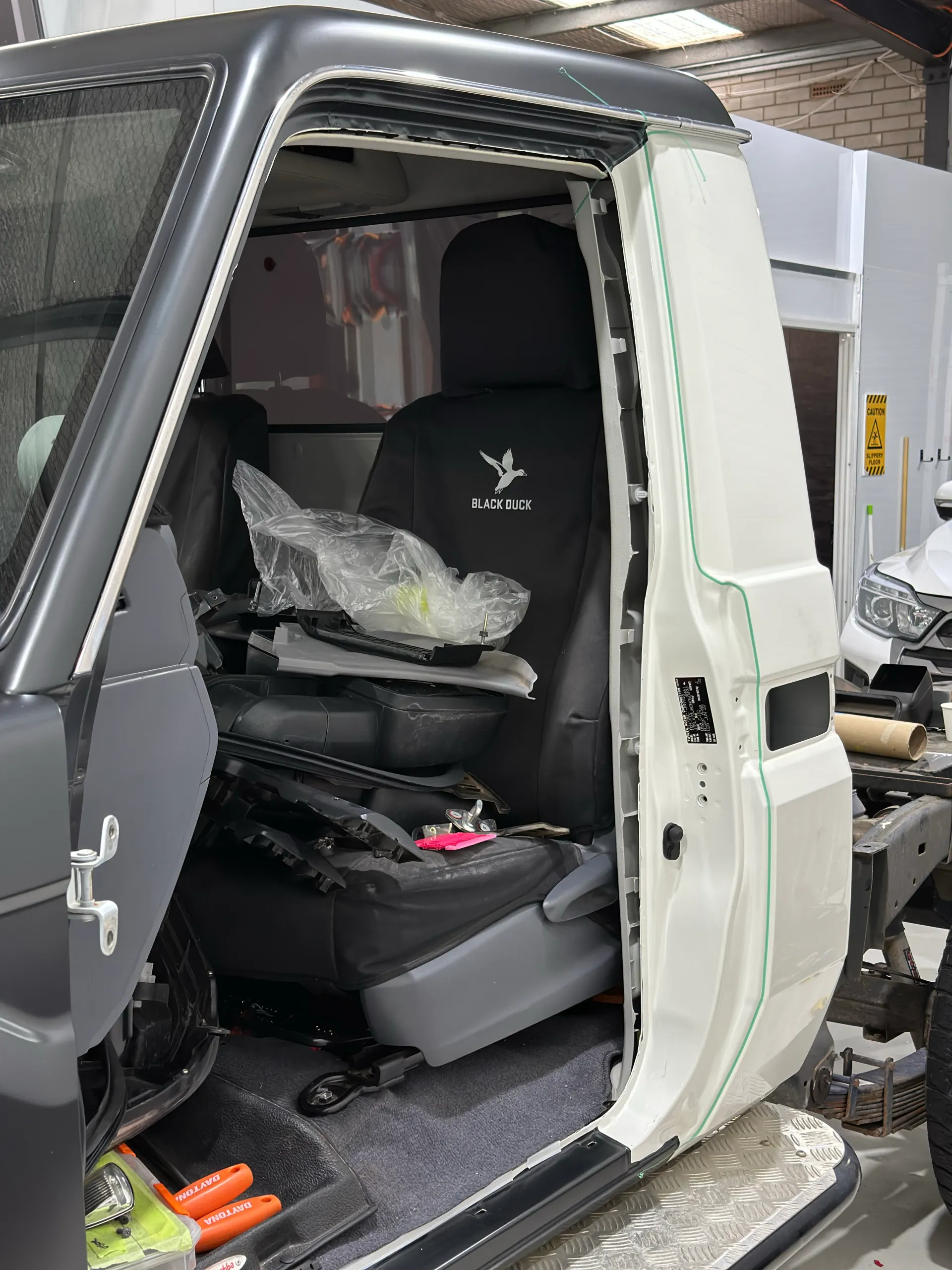 LandCruiser door opening during wrapping, with white jamb sections beside dark grey outer panels