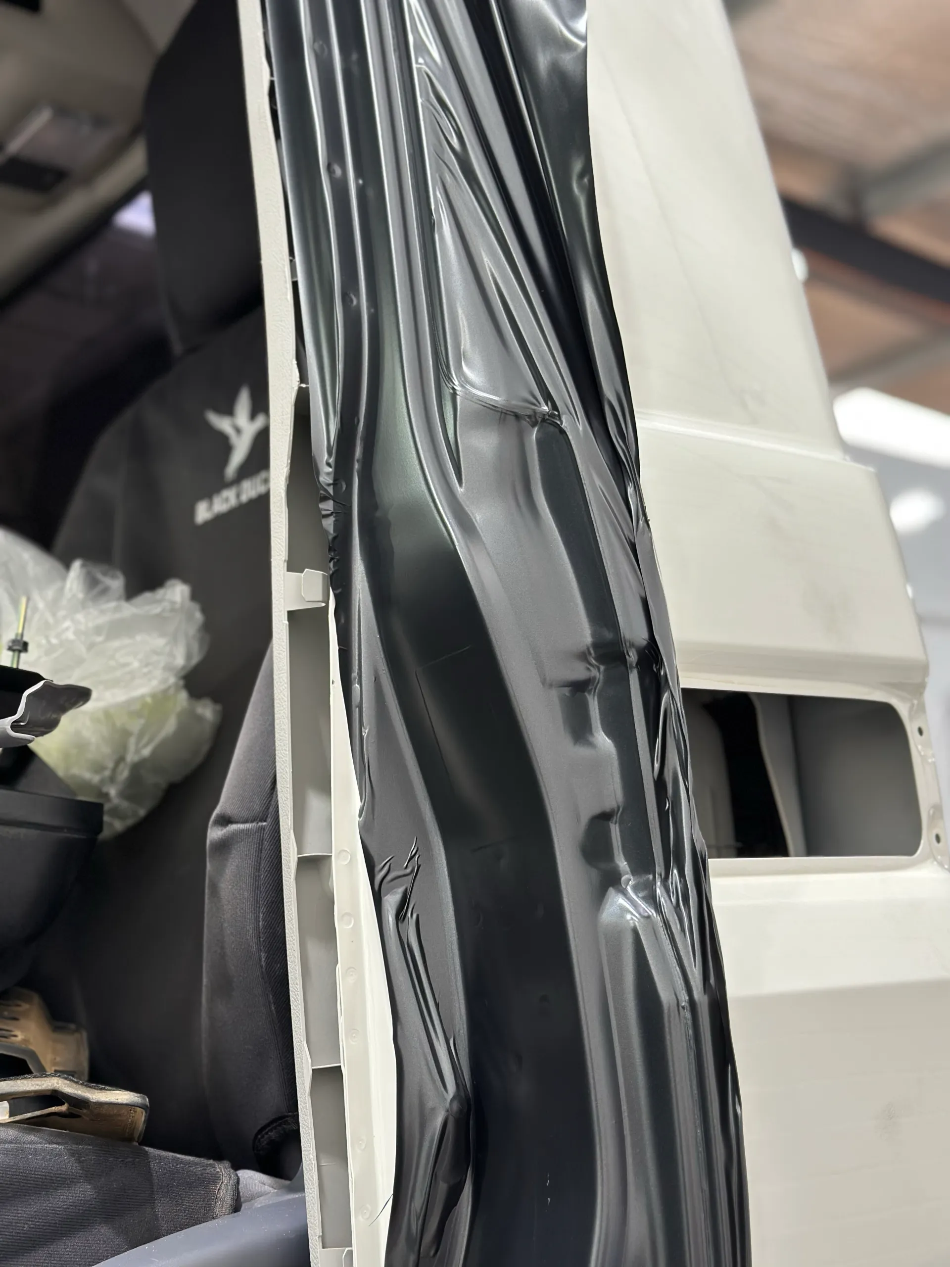 Loose dark film around a LandCruiser door jamb during installation