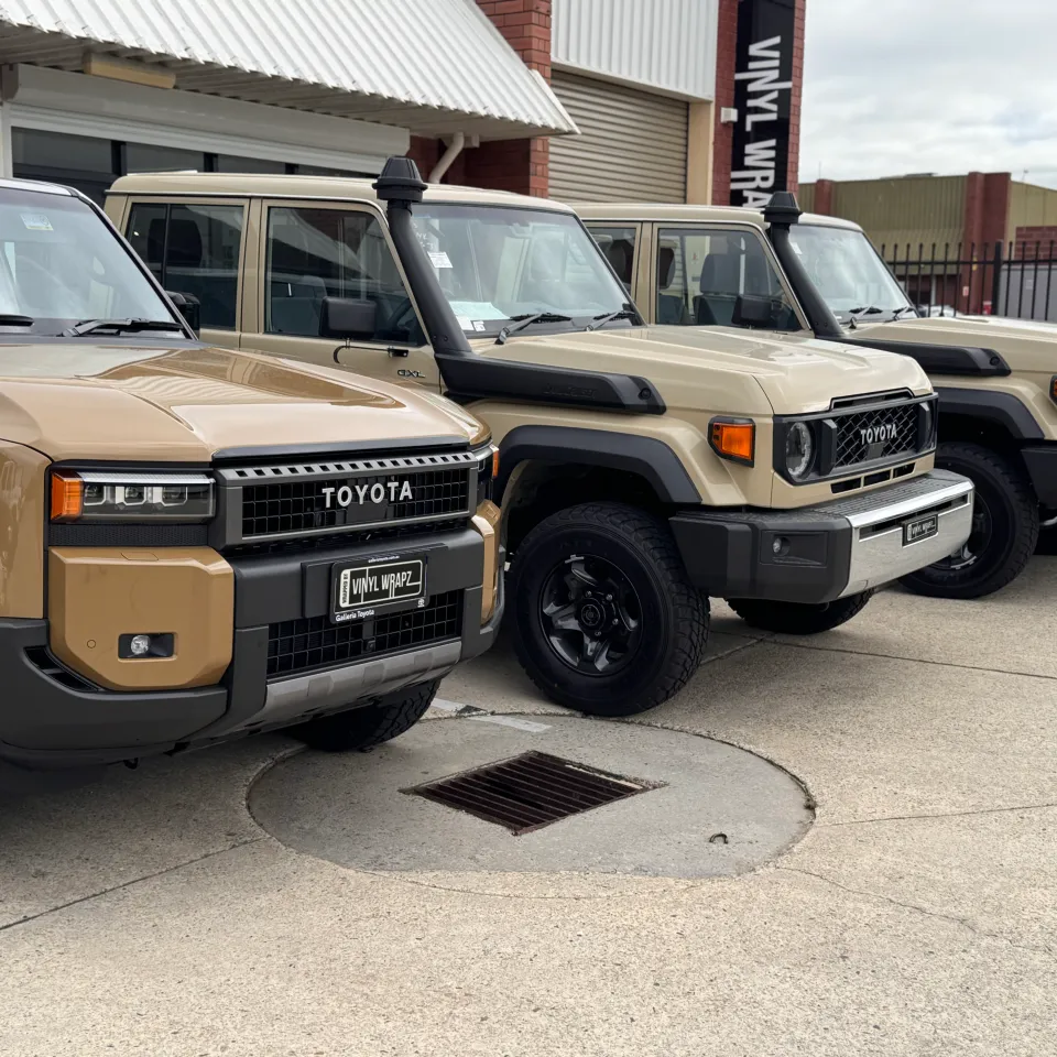 Tan Toyota LandCruiser vehicles parked in a row outside Vinyl Wrapz