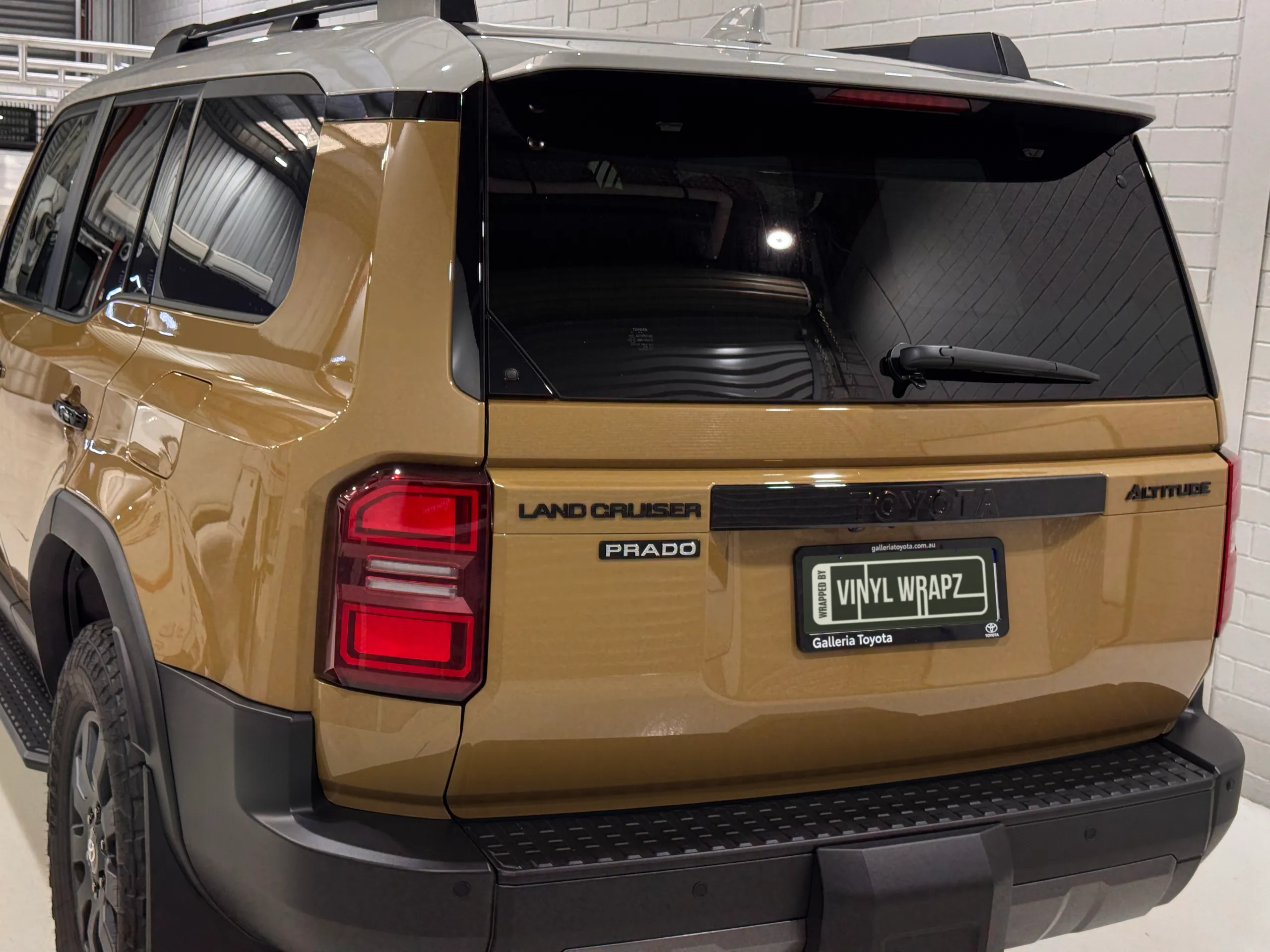 Rear-quarter view of the gloss gold Toyota LandCruiser Prado Altitude