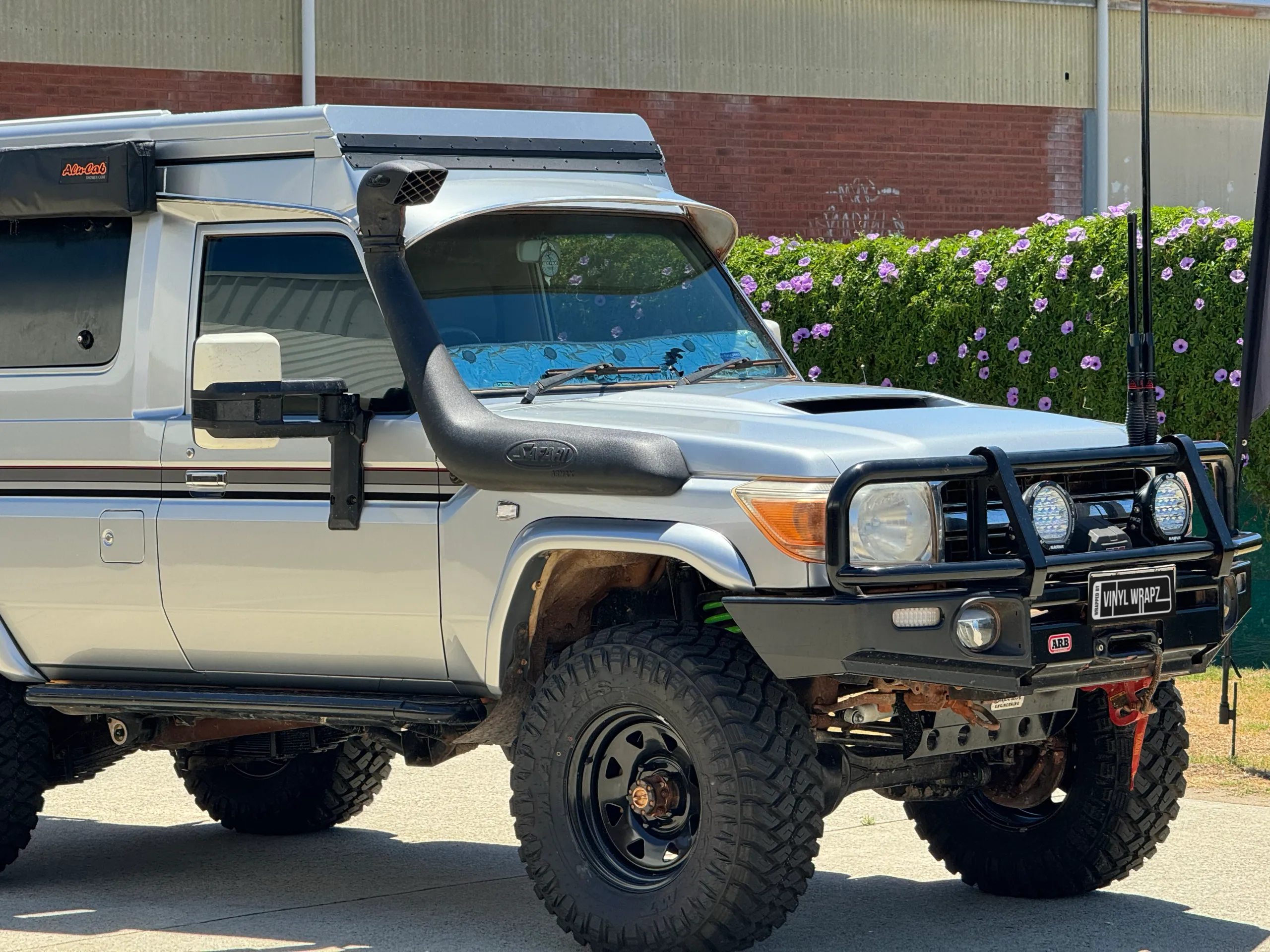 Silver Toyota LandCruiser Troop Carrier with camper roof, front detail