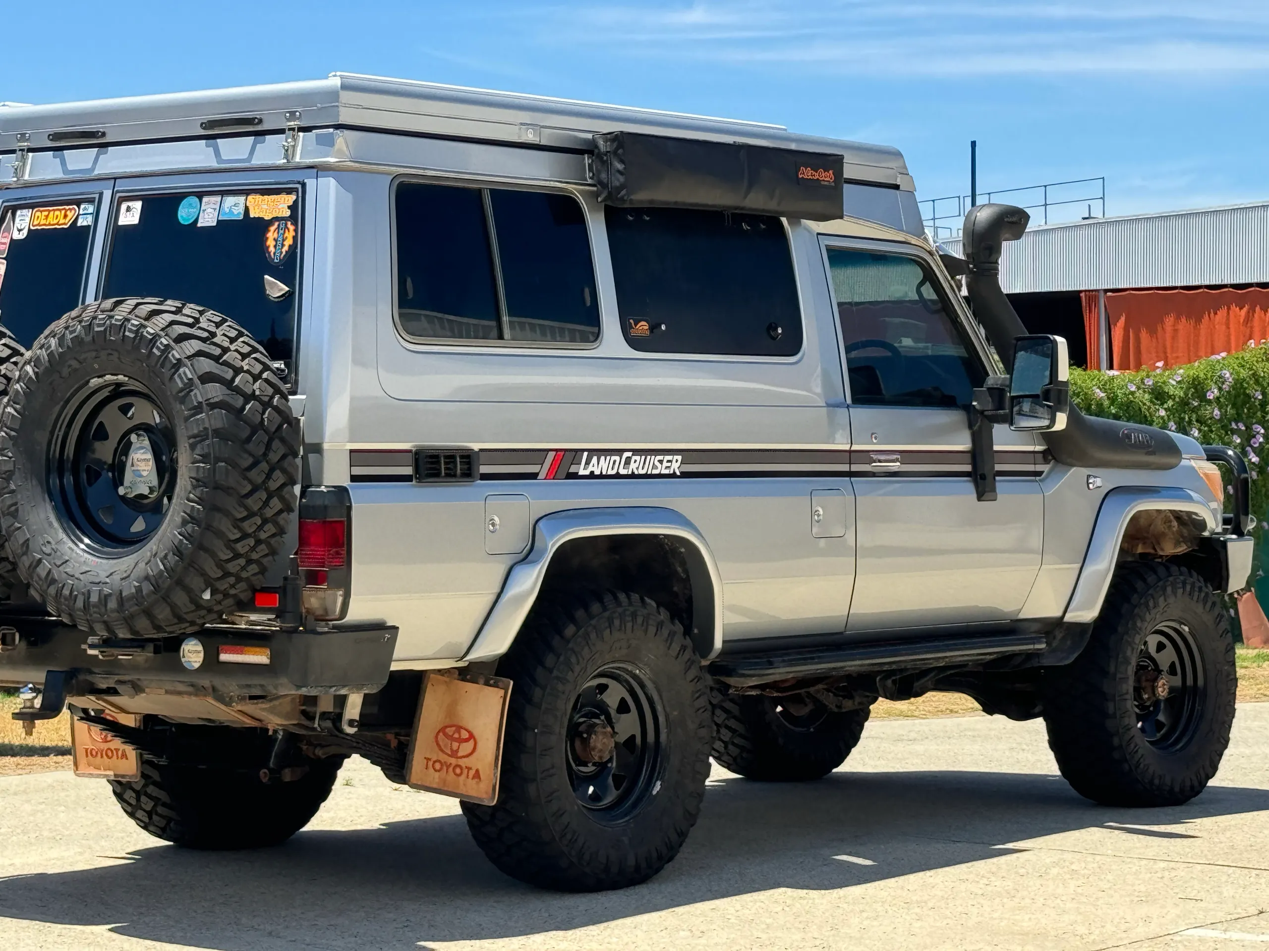 Silver Toyota LandCruiser Troop Carrier with camper roof, rear quarter