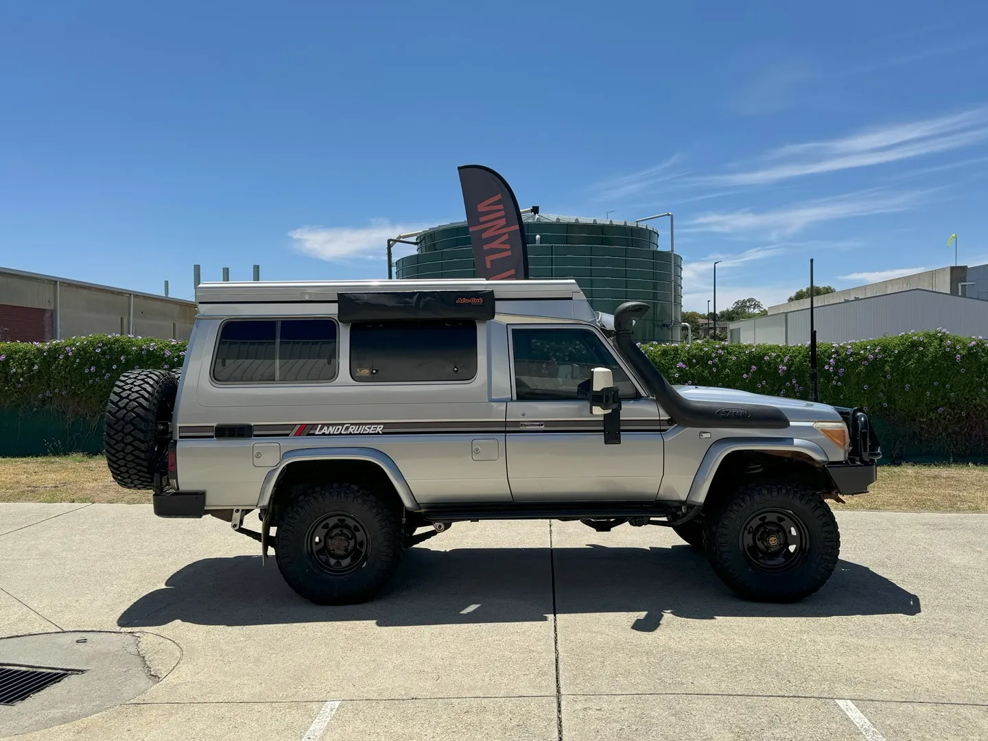 Silver Toyota LandCruiser Troop Carrier with camper roof, side