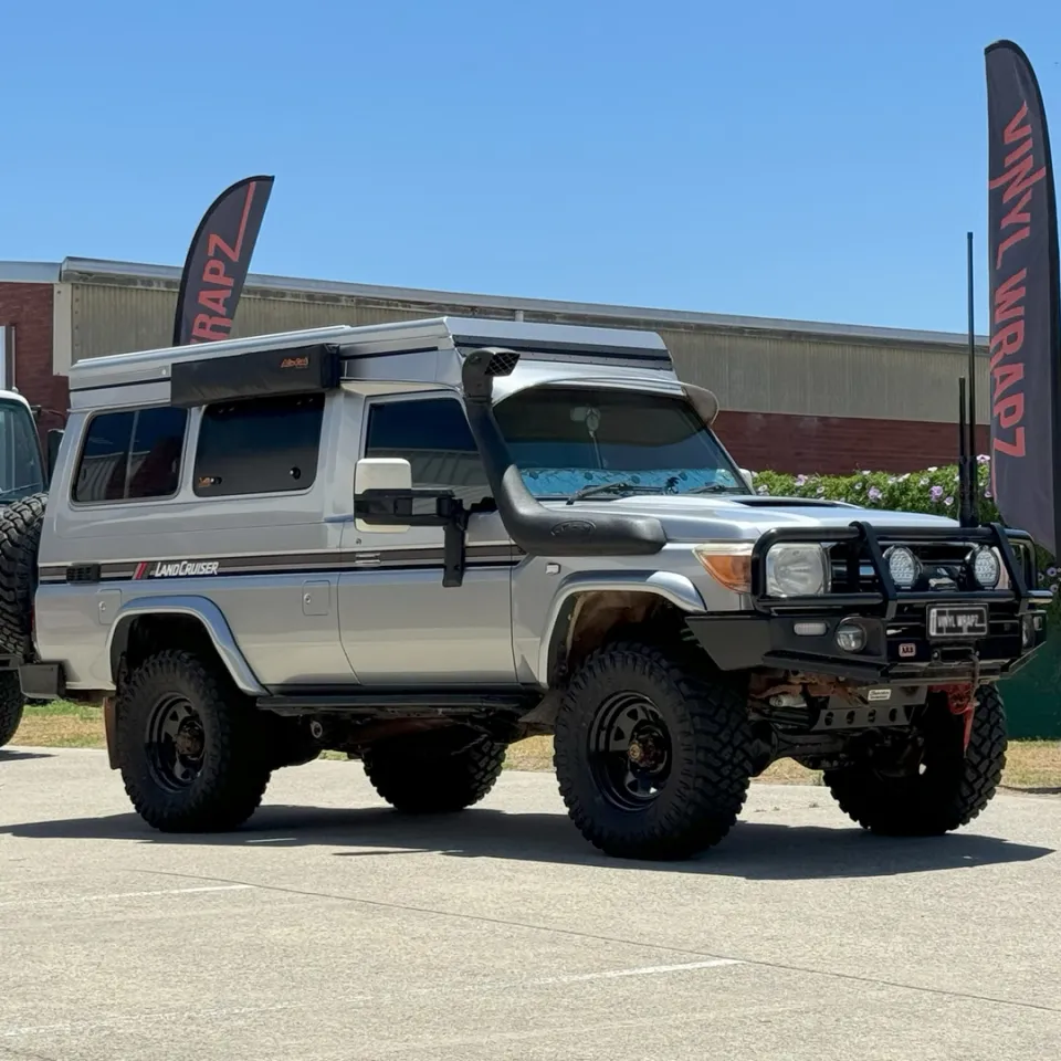 Silver Toyota LandCruiser Troop Carrier with camper roof, front quarter