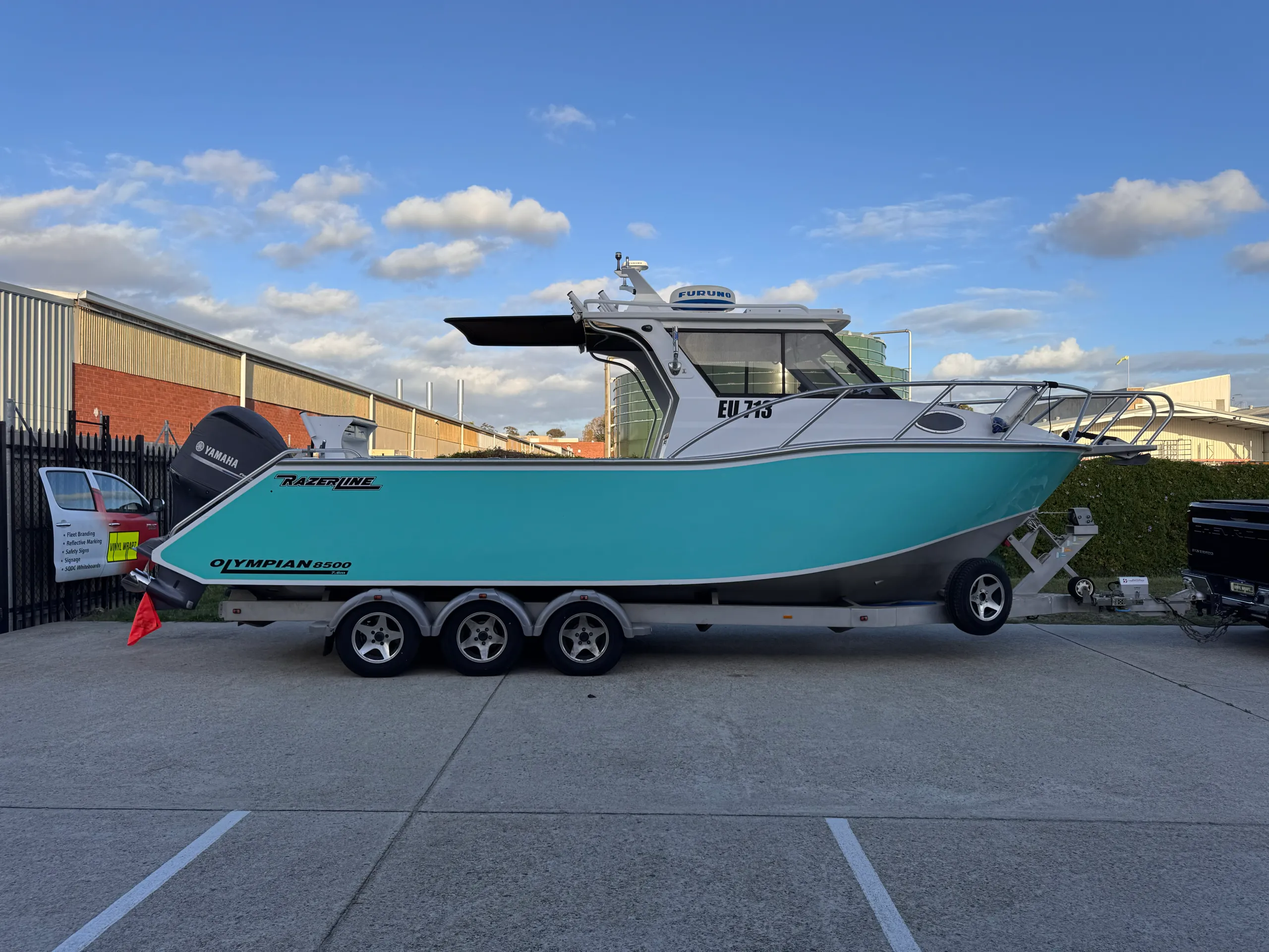 Full side view of the turquoise Razerline Olympian on its trailer outdoors