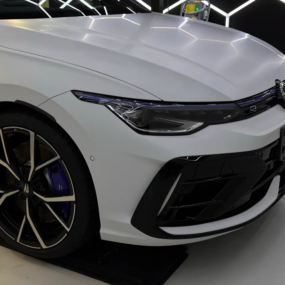 White Golf R bonnet, front wheel and grille inside the workshop