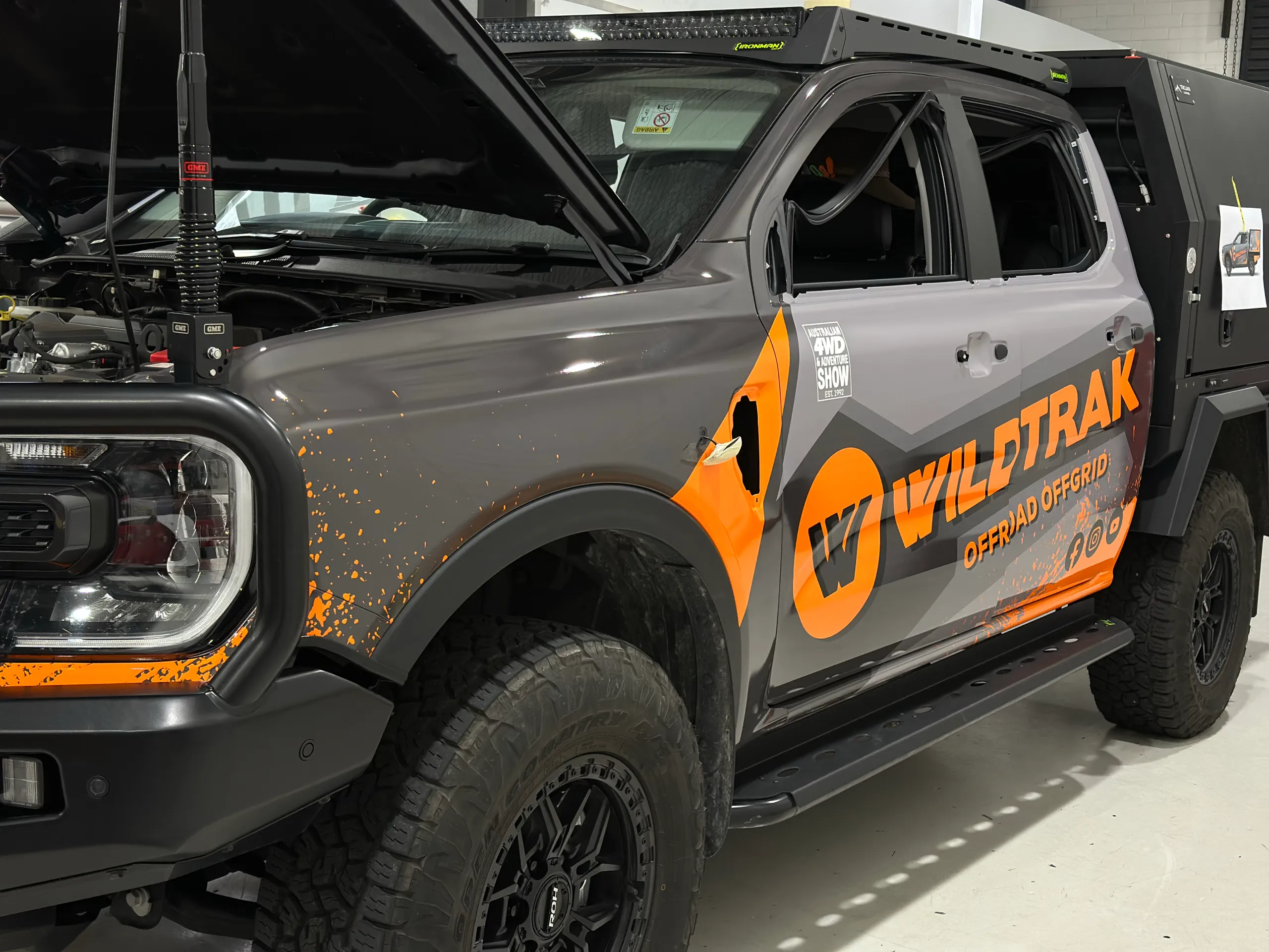 Ford Ranger cab during wrapping, with Wildtrak branding applied and mirrors and door handles removed