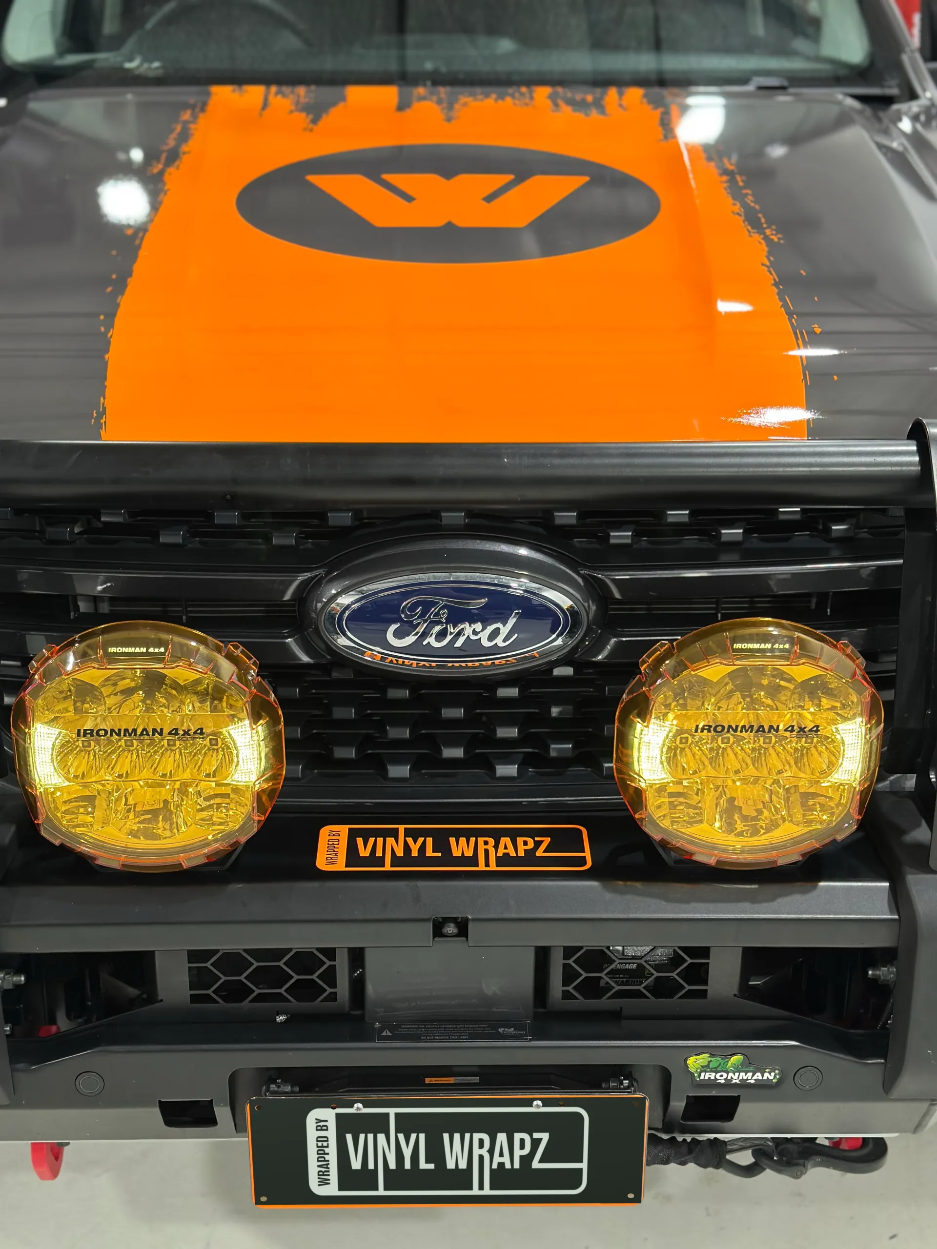 Front view of the Ford Ranger grille, bull bar and orange Wildtrak bonnet graphic
