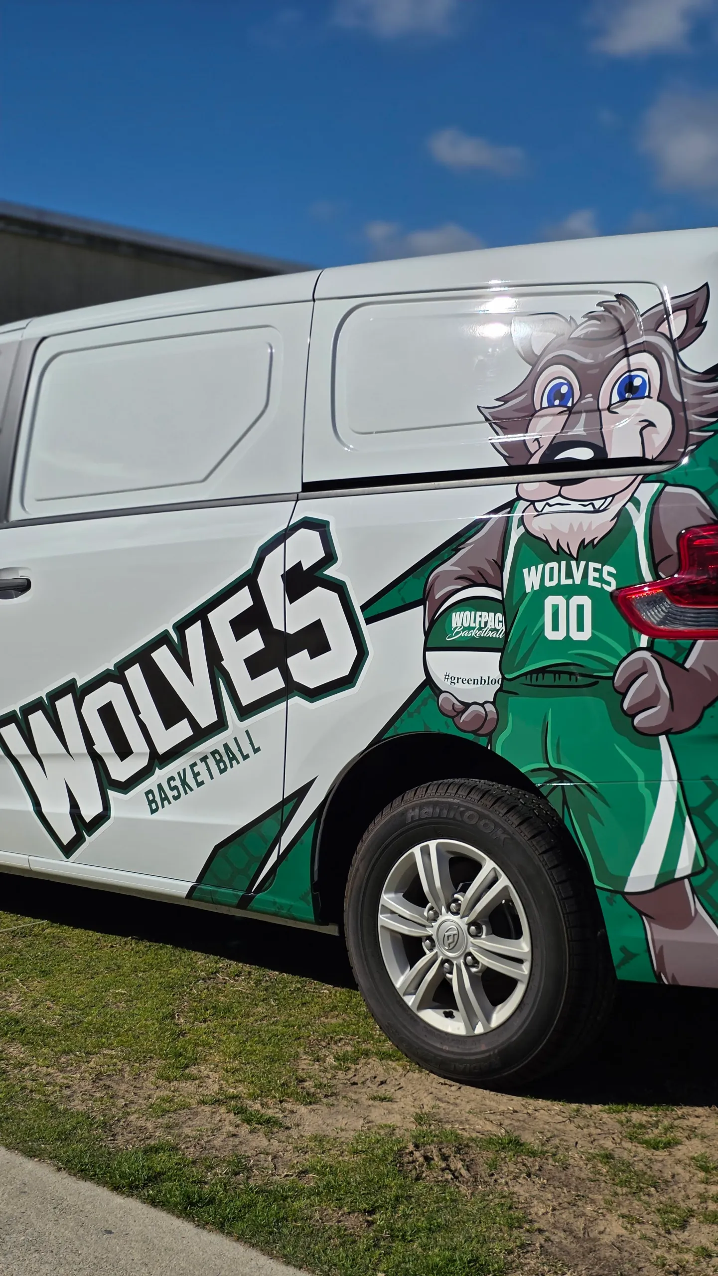 Wolves Basketball lettering and a wolf mascot across the side of a white LDV van