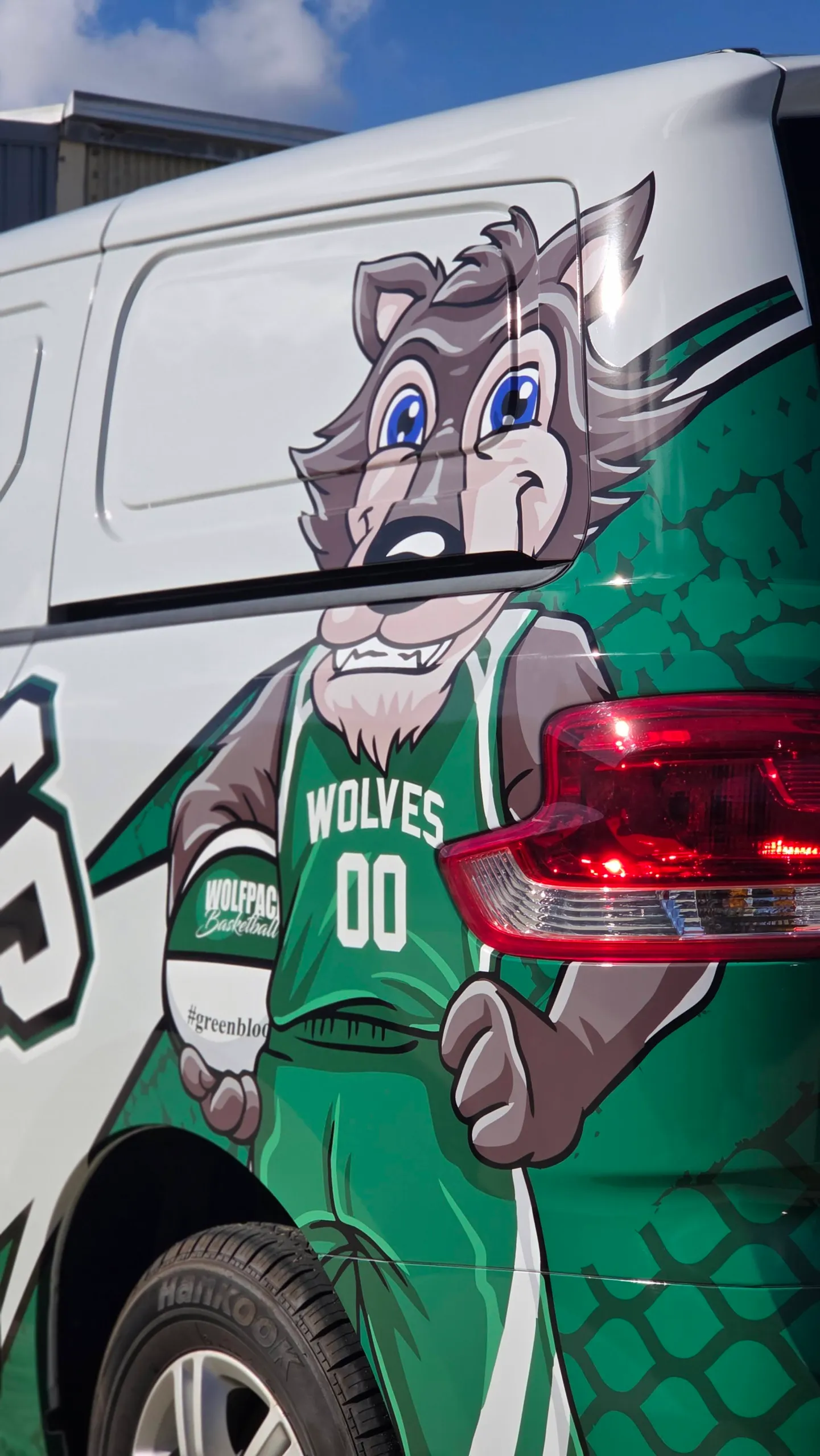 Wolves mascot in a green basketball uniform printed beside the LDV van rear light