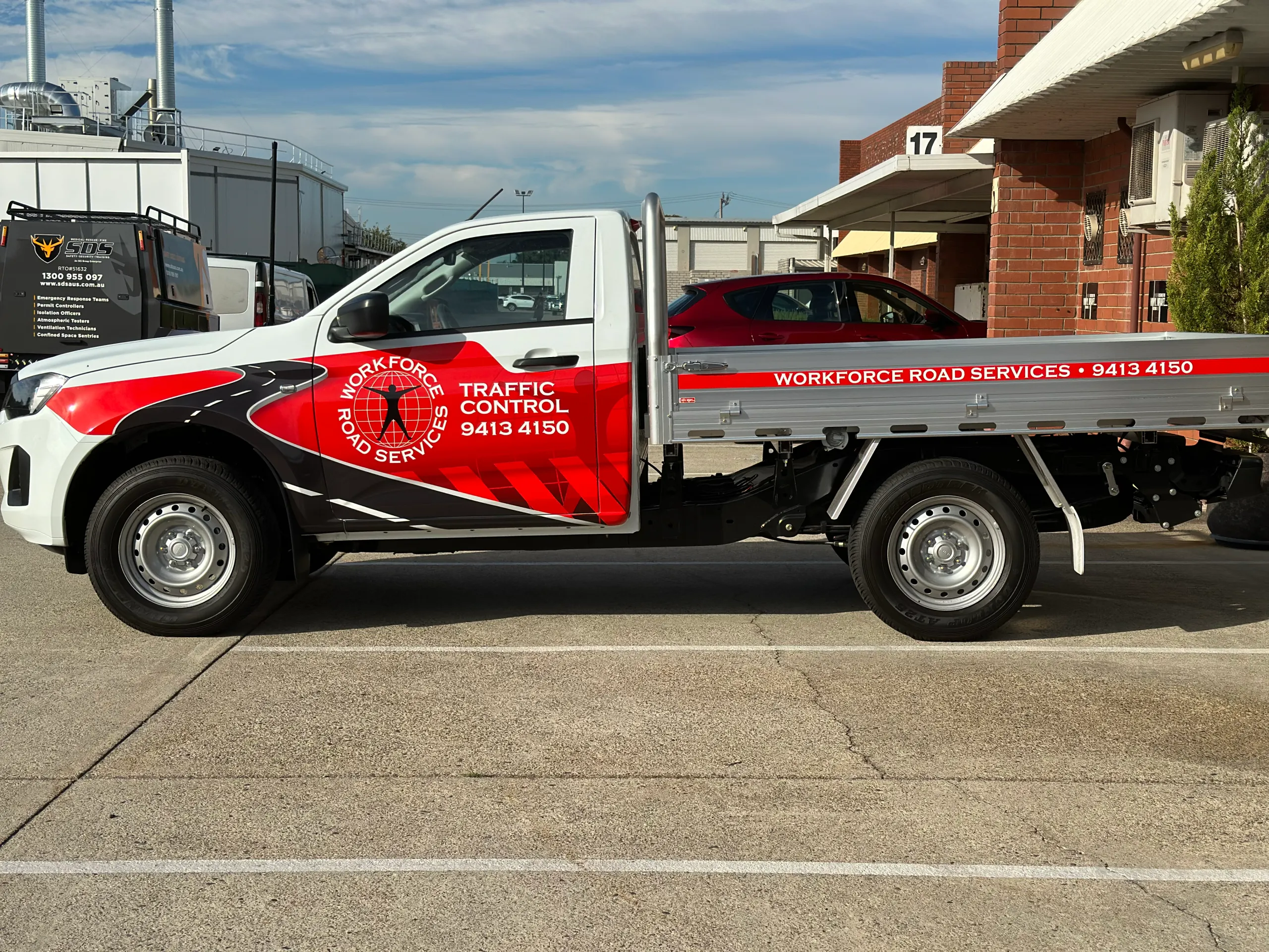 White Isuzu D-MAX tray ute with red and black Workforce Road Services graphics