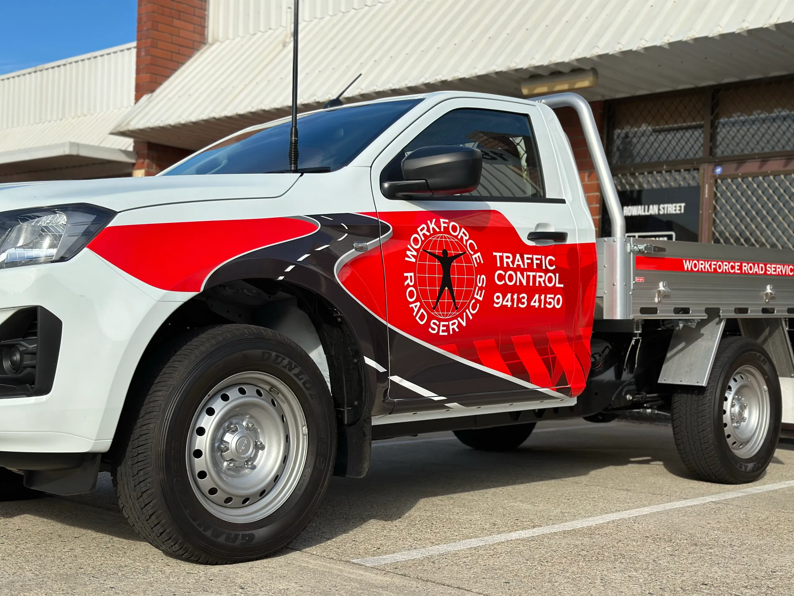 Red Workforce traffic control graphics across the Isuzu ute door and front guard