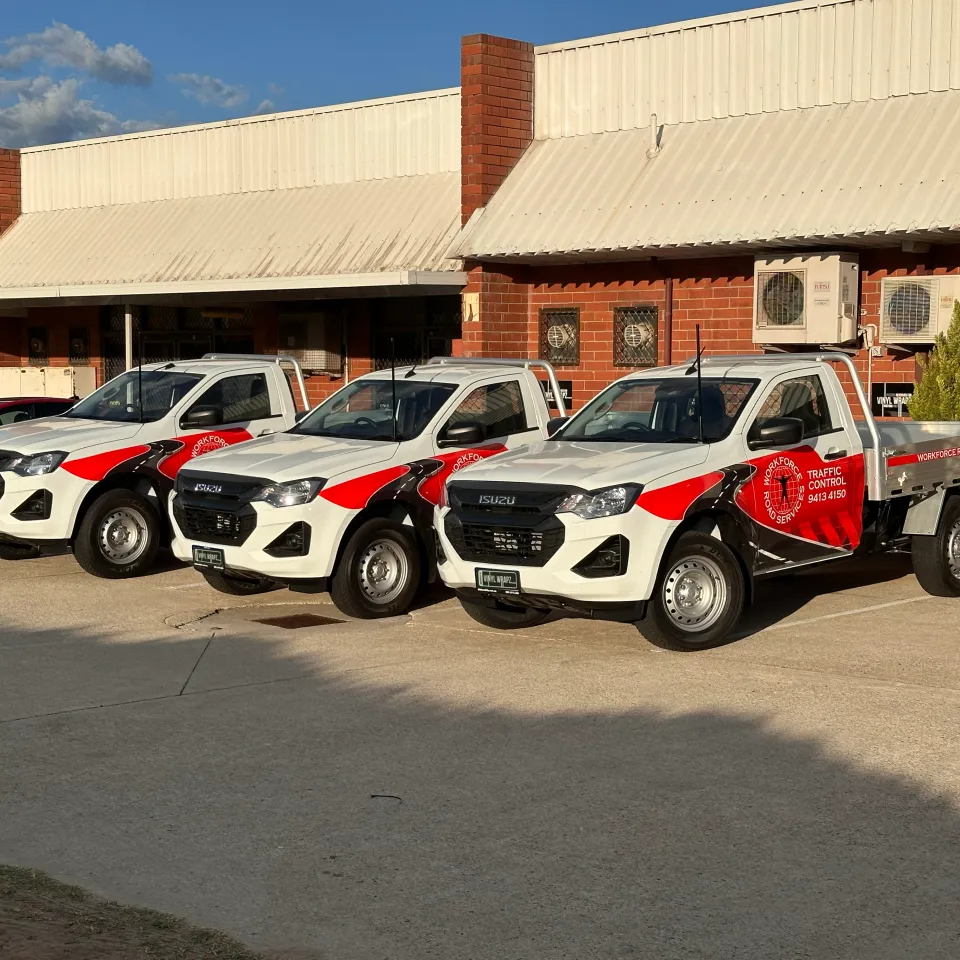 Workforce Road Services fleet of three white Isuzu tray utes with red and black graphics