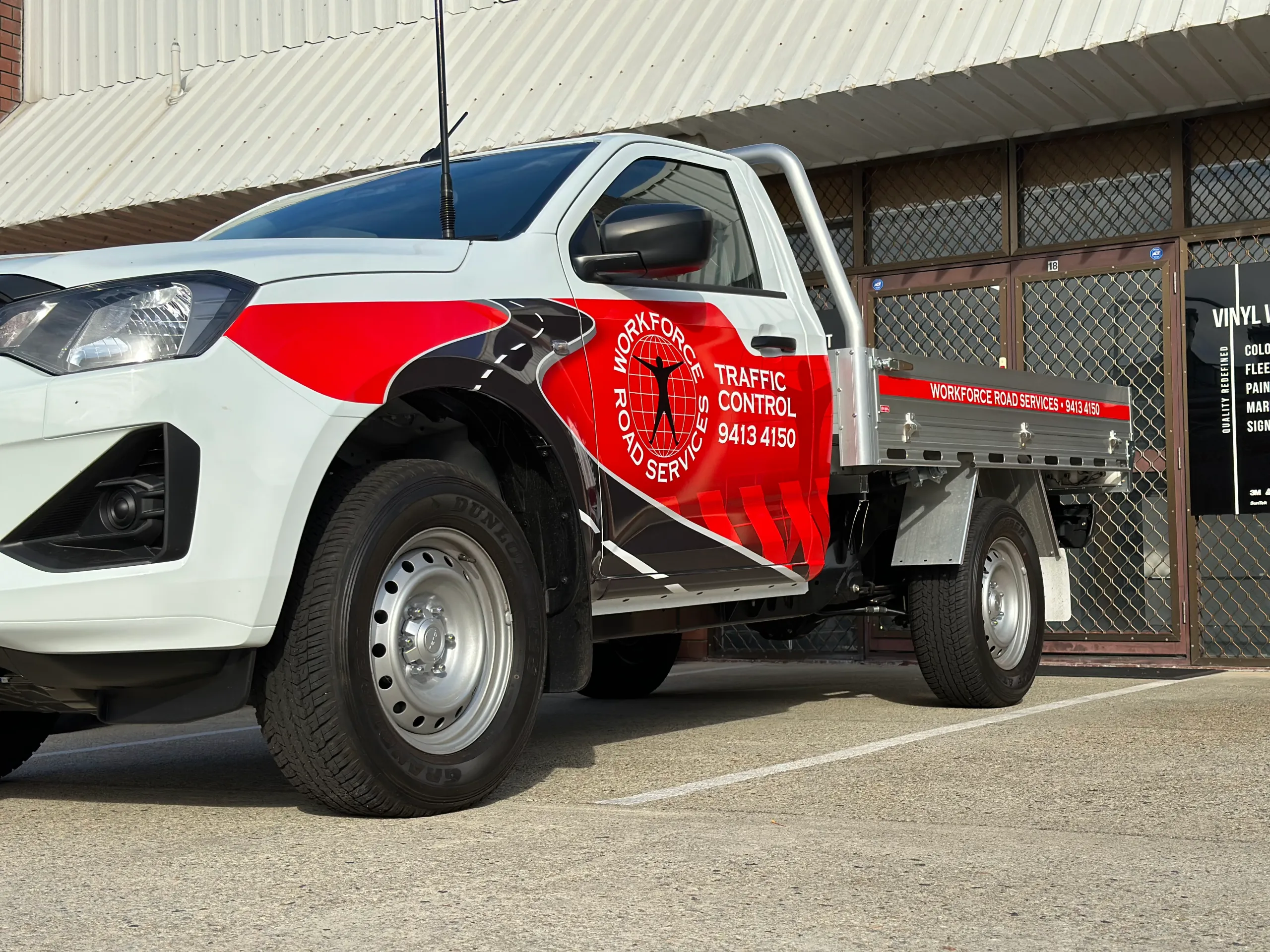 Workforce Road Services door logo and red graphics on a white Isuzu ute