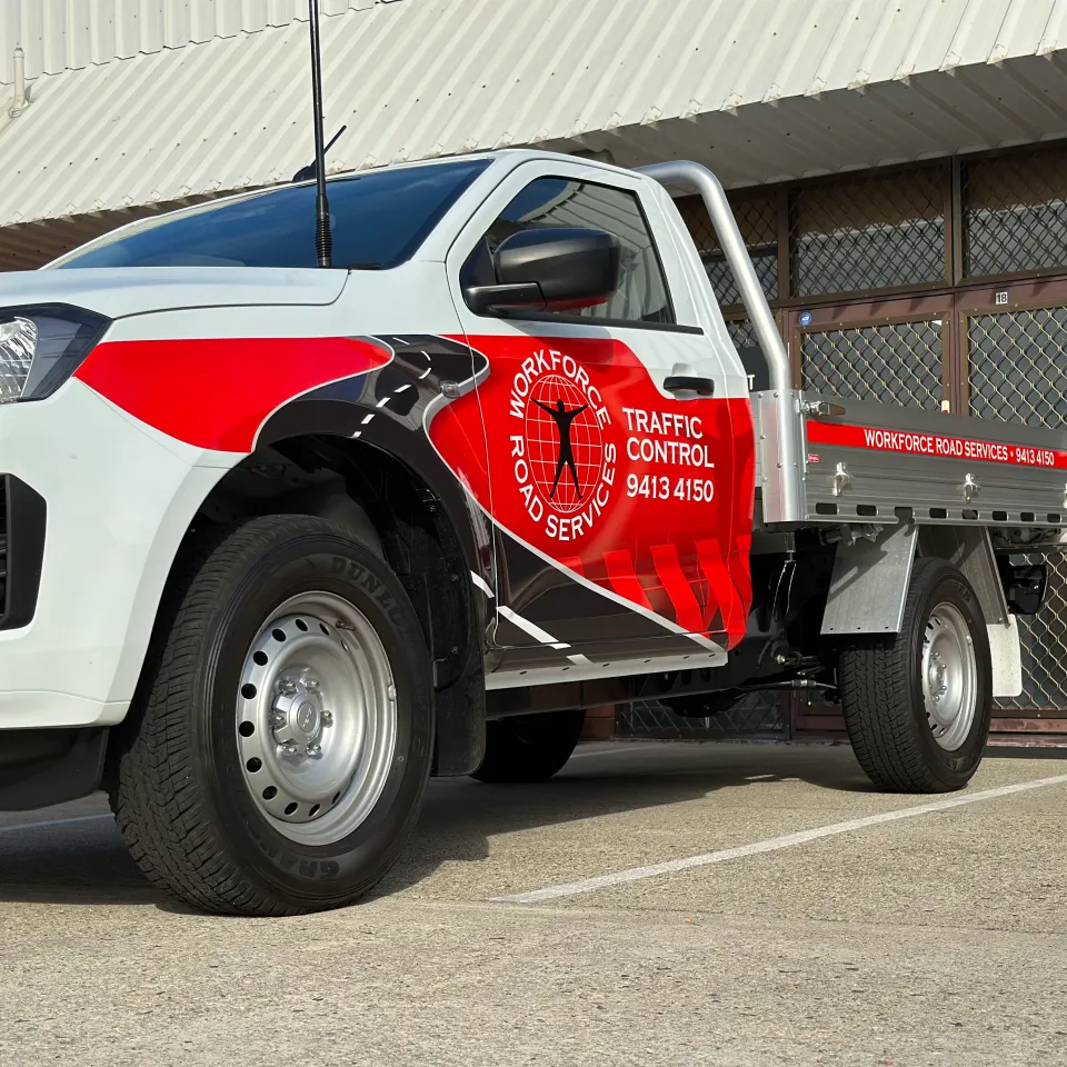 Workforce Road Services door logo and red graphics on a white Isuzu ute