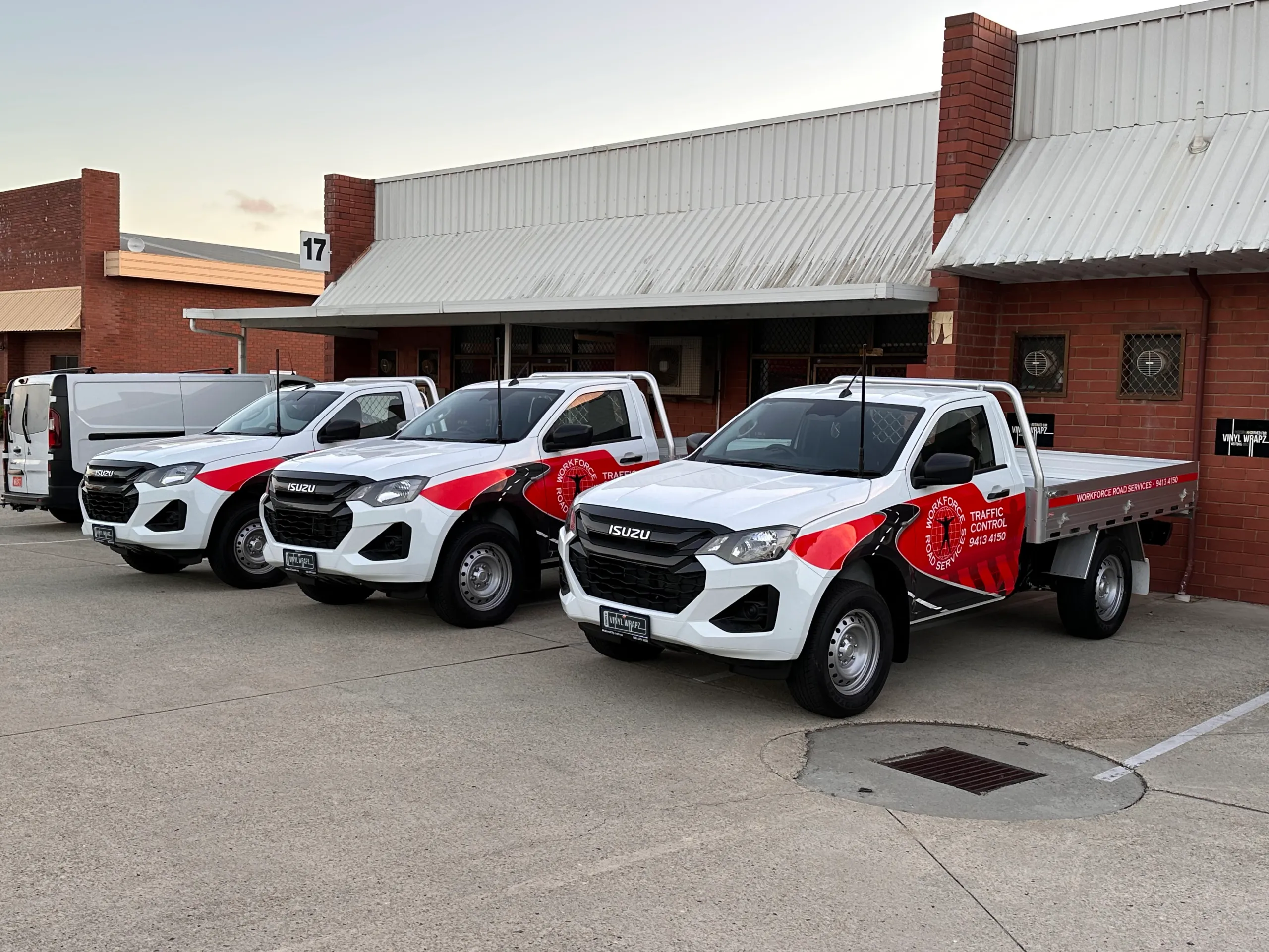 Three Workforce Road Services Isuzu tray utes lined up outside the workshop