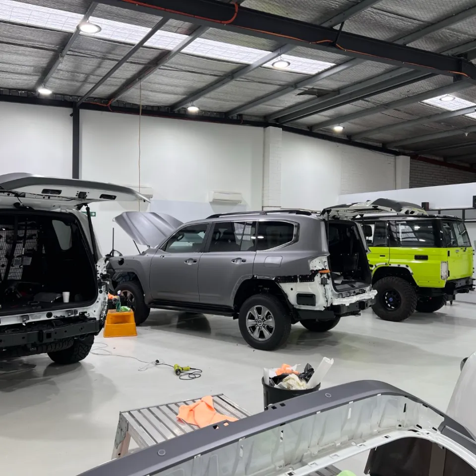 Several LandCruisers dismantled for wrapping with loose body panels on stands