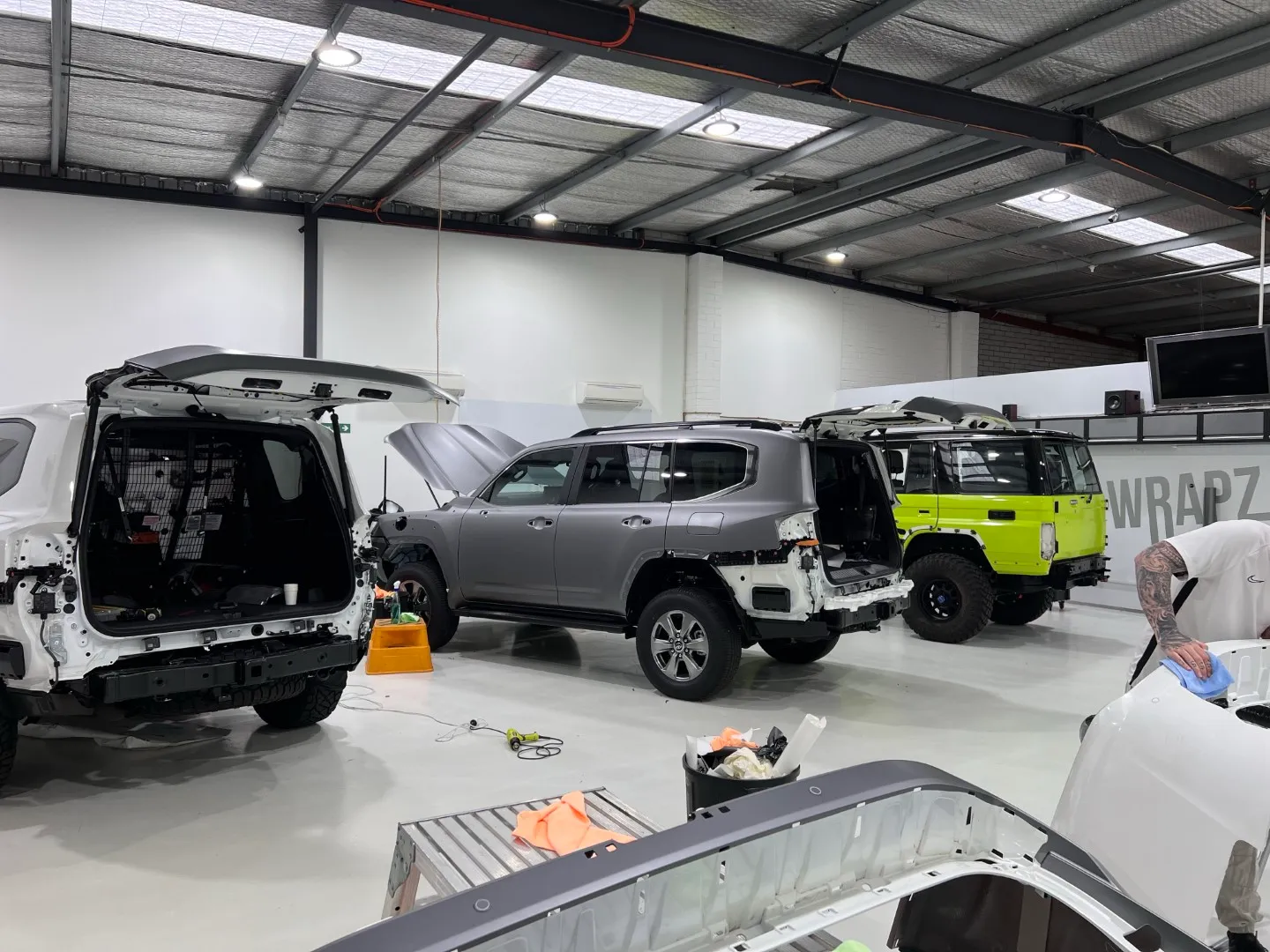 Several LandCruisers dismantled for wrapping with loose body panels on stands