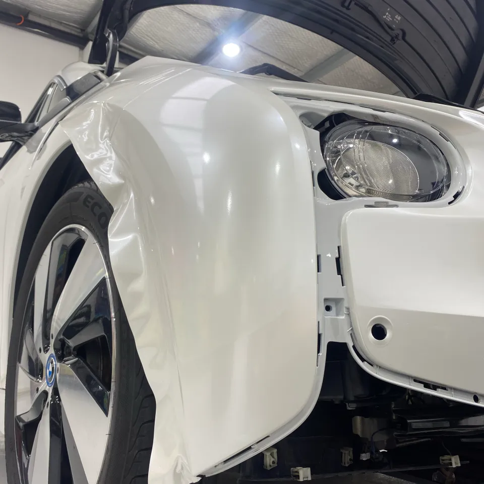 White film being fitted to a BMW i3 front wing with bumper removed