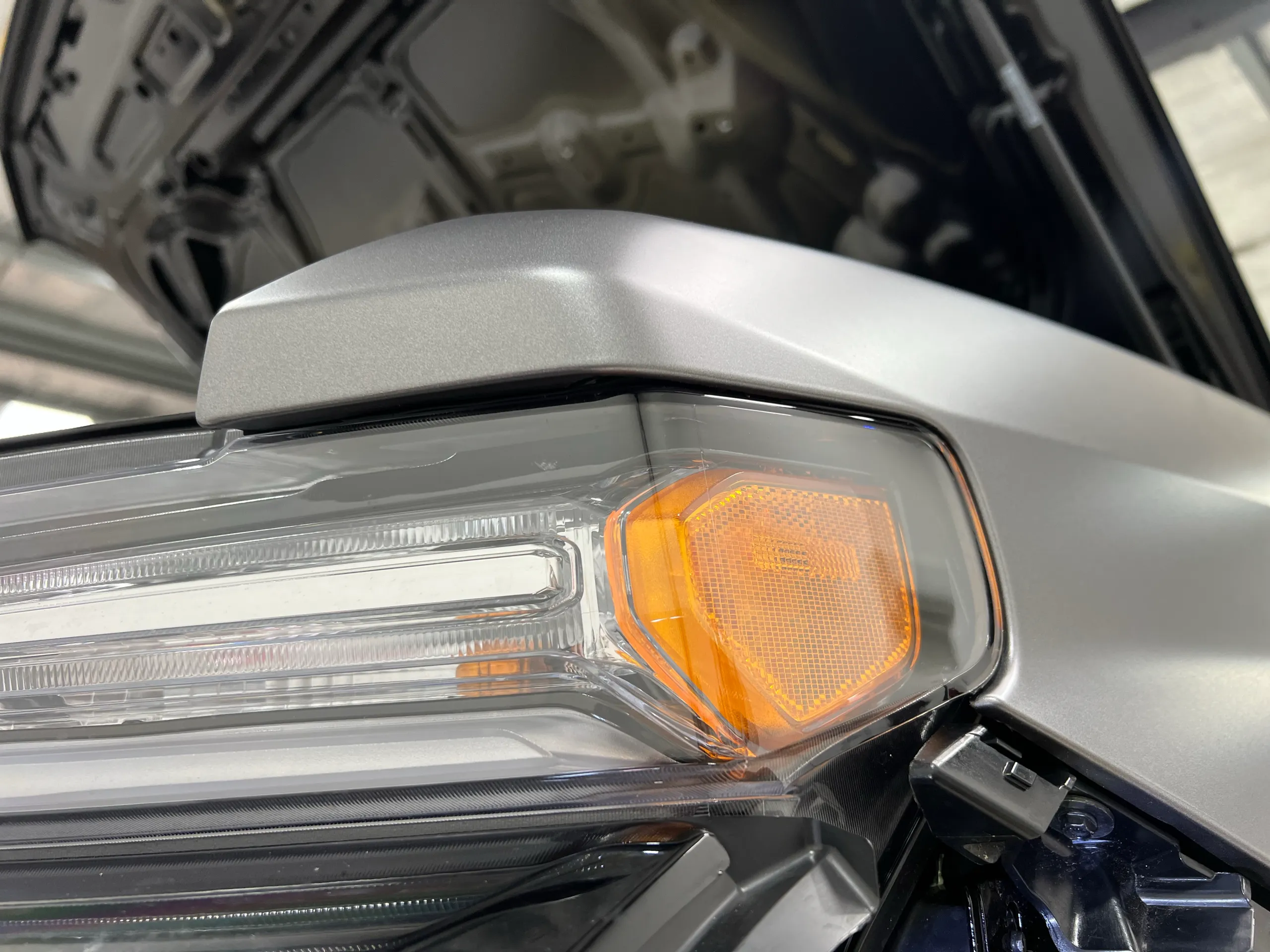 Silver film fitted around the headlight with nearby trim removed