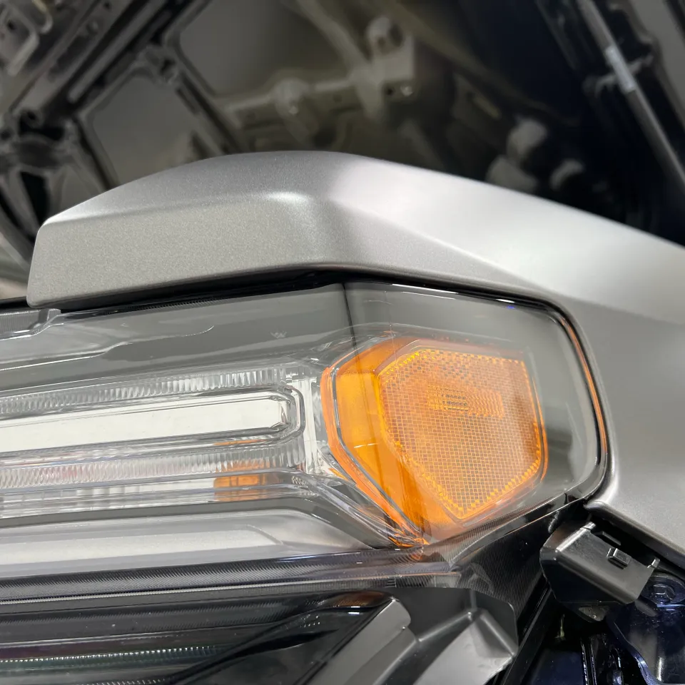 Silver film fitted around the headlight with nearby trim removed